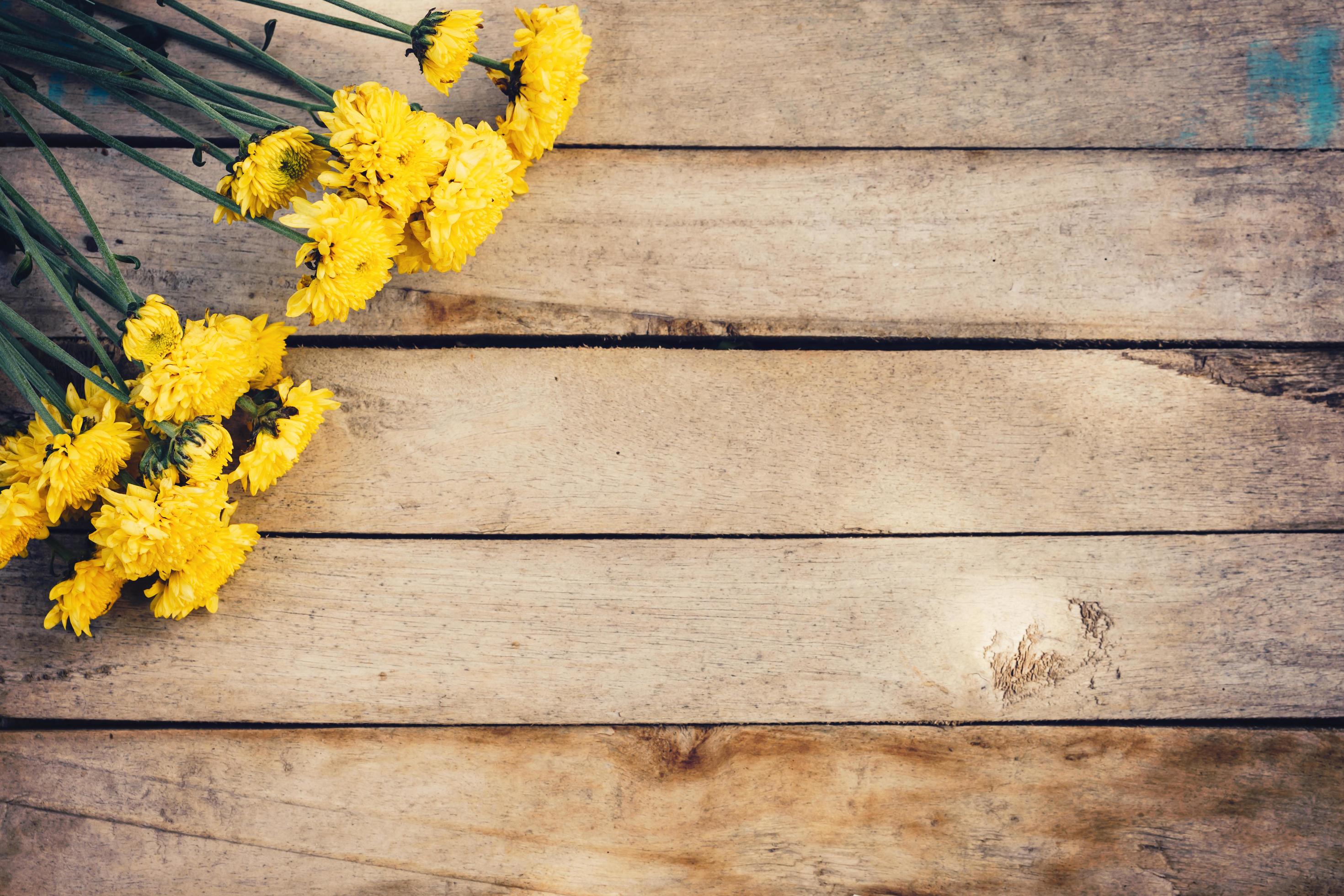 Yellow flowers of bouquet, top view on wooden background texture with copy space Stock Free