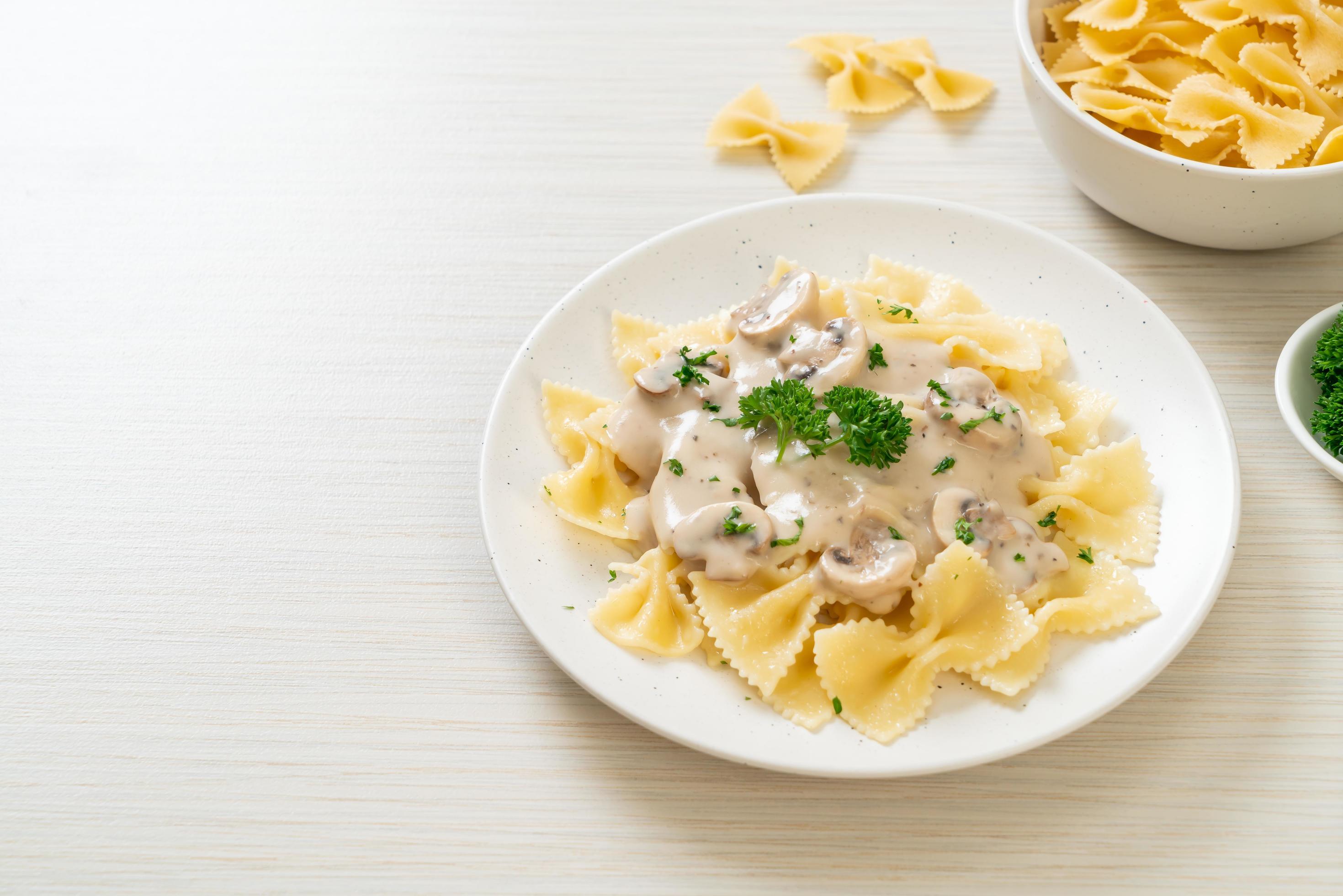 Farfalle pasta with mushroom white cream sauce – Italian food style Stock Free