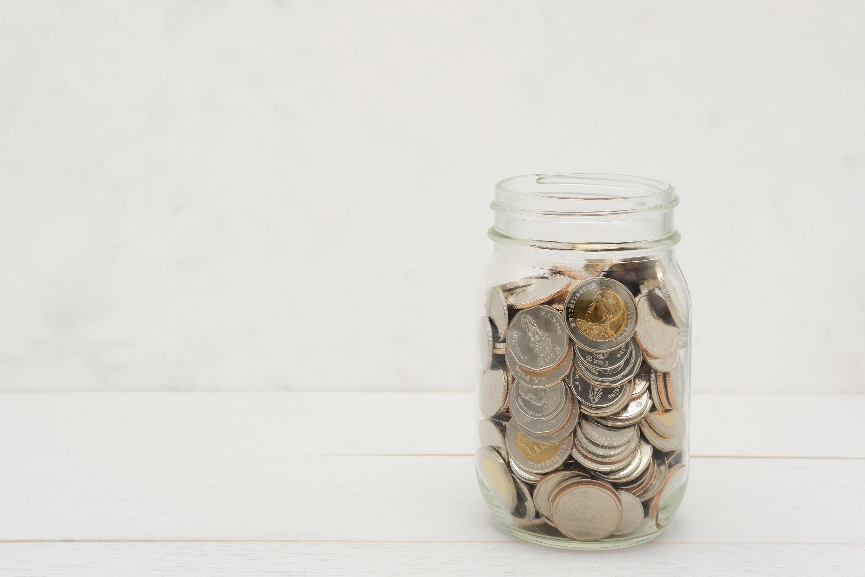 Thai Baht coins in a glass jar. Business and finance concept. Stock Free