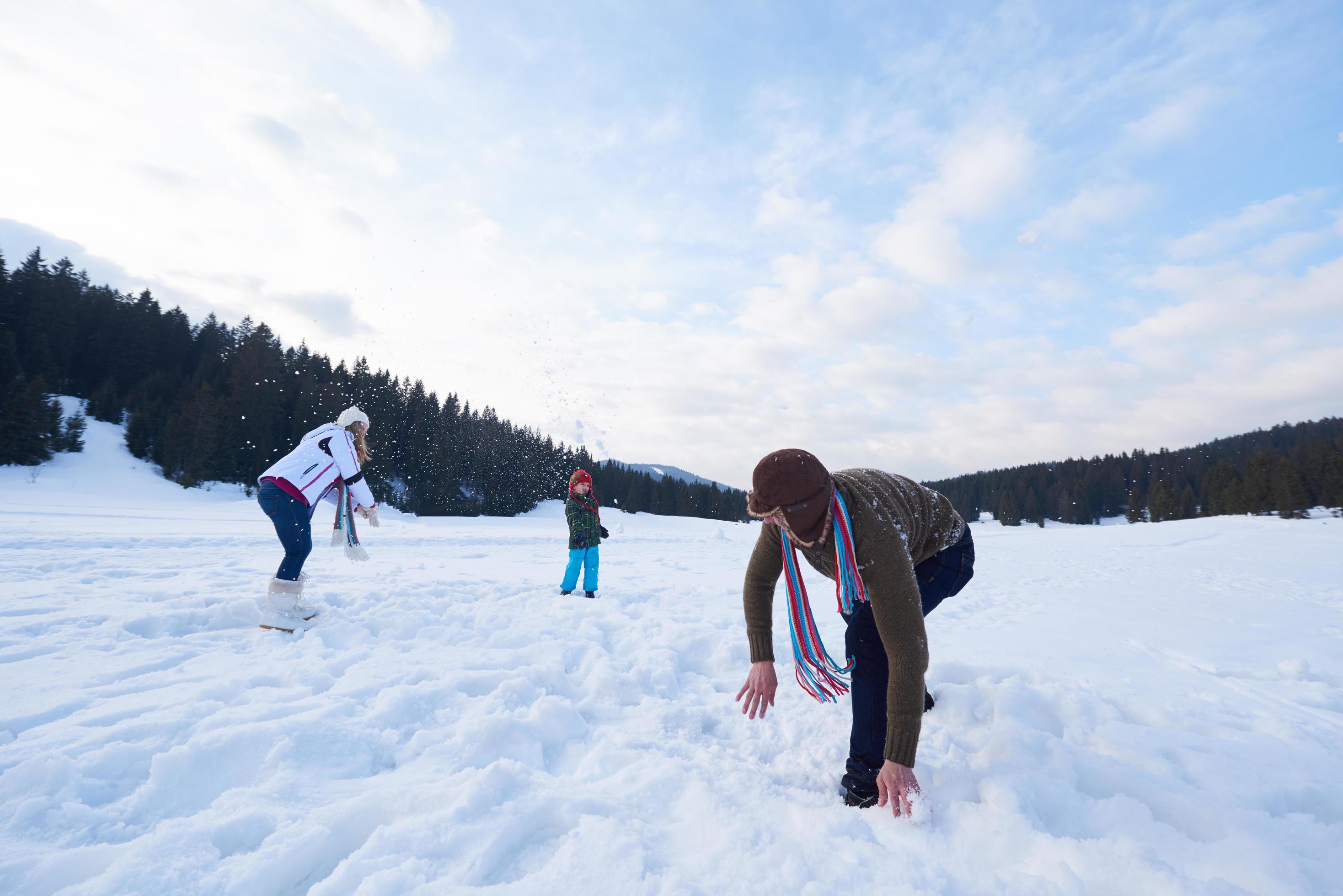 happy family playing together in snow at winter Stock Free