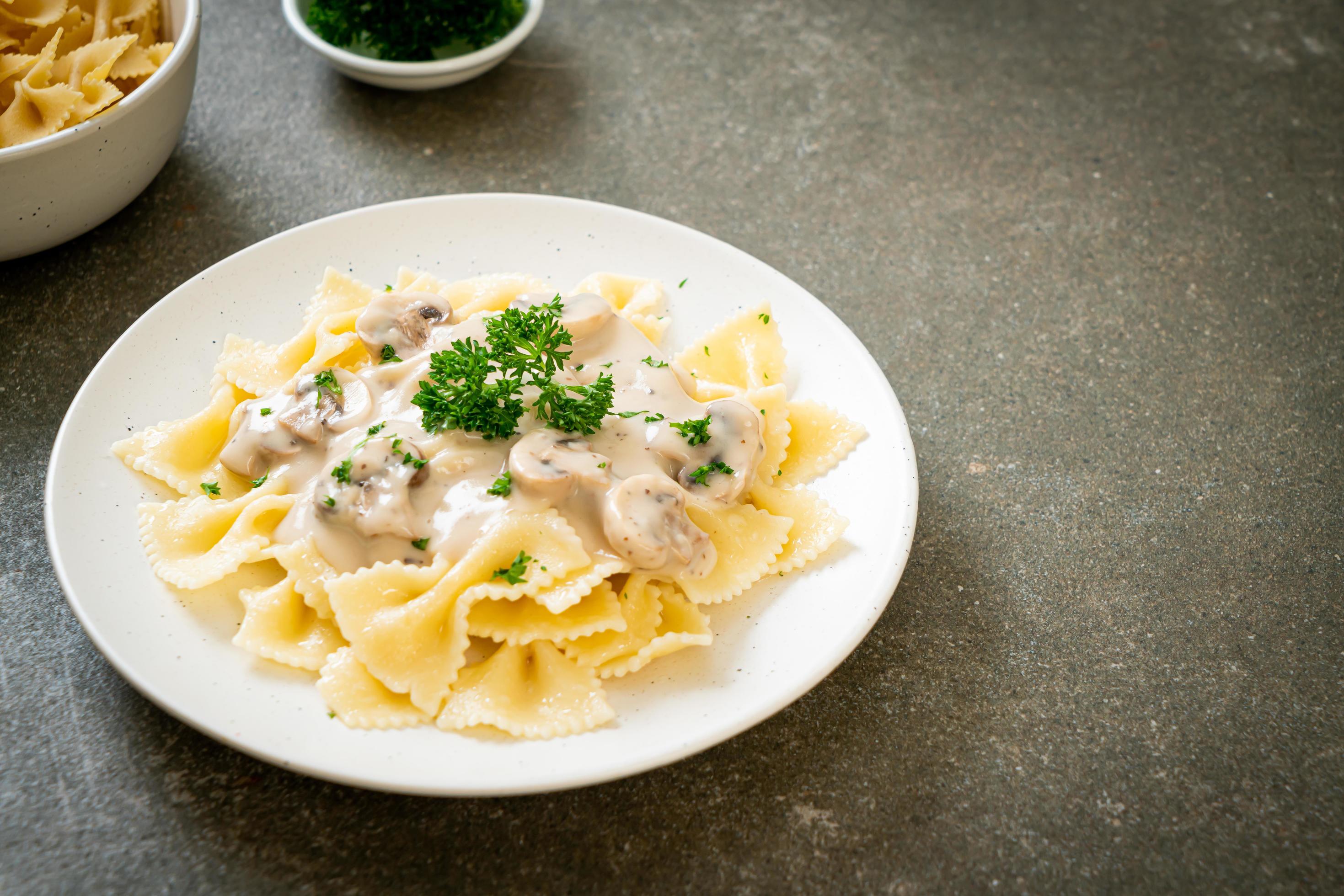 Farfalle pasta with mushroom white cream sauce – Italian food style Stock Free