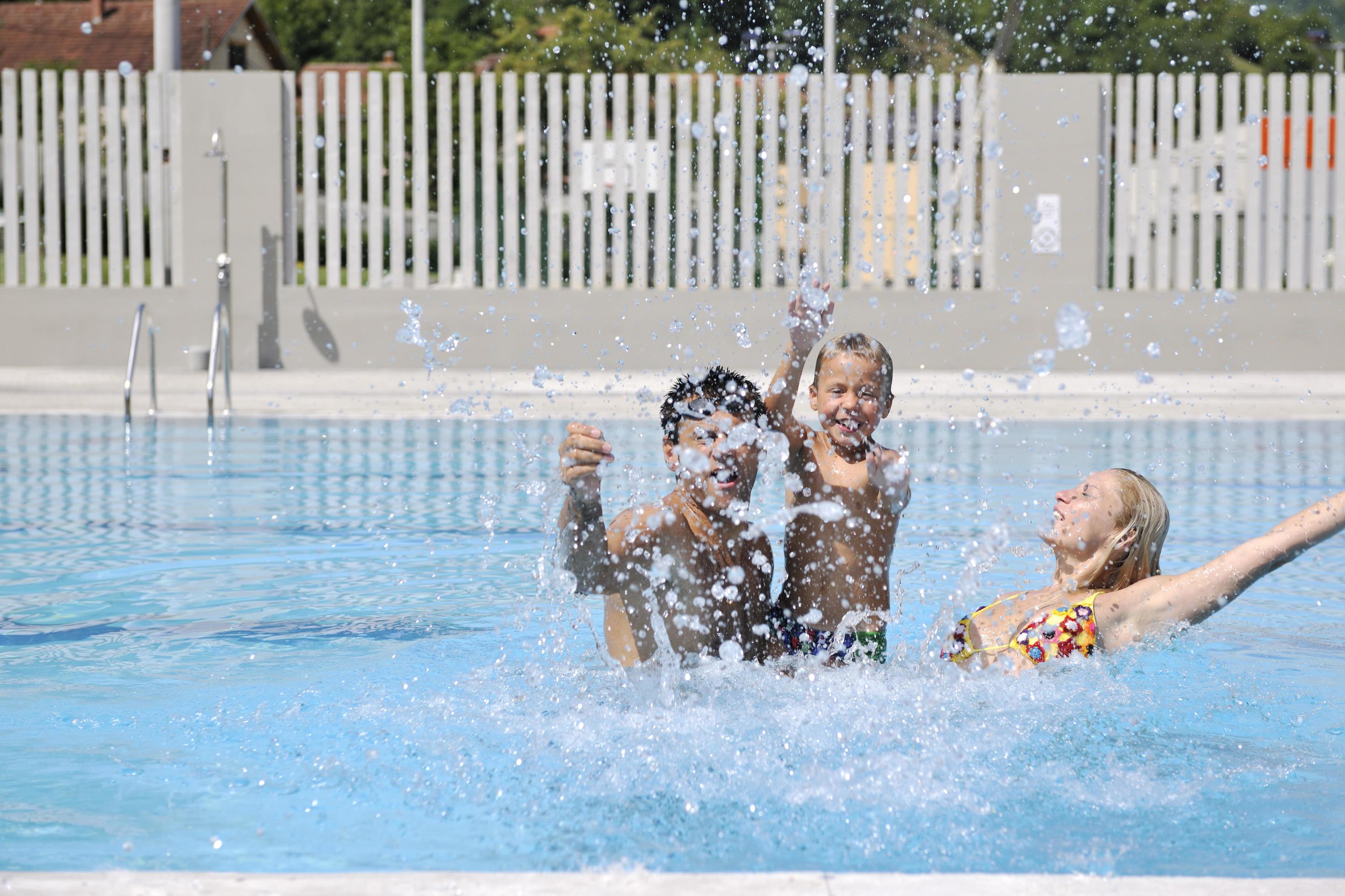 happy young family have fun on swimming pool Stock Free