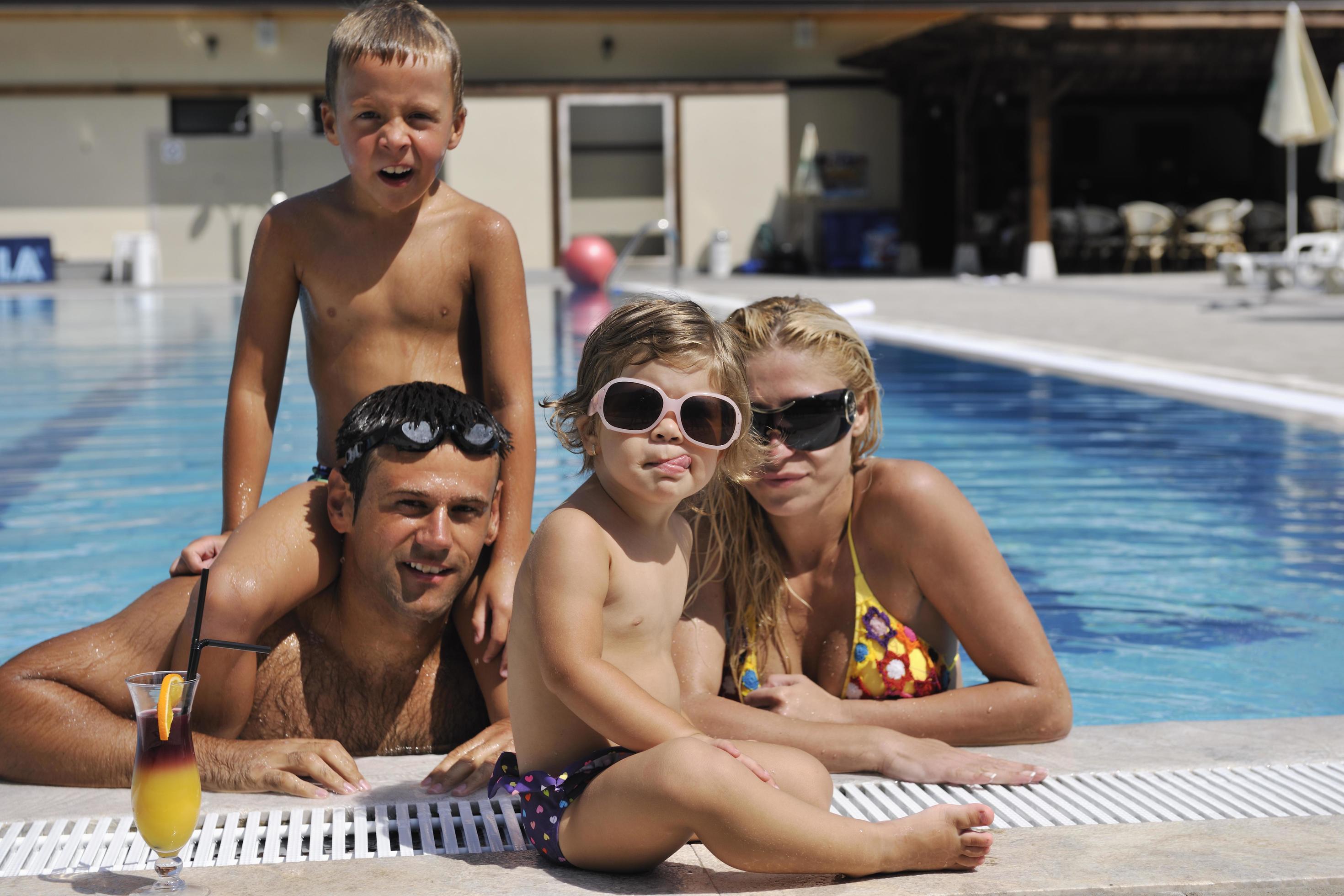 happy young family have fun on swimming pool Stock Free