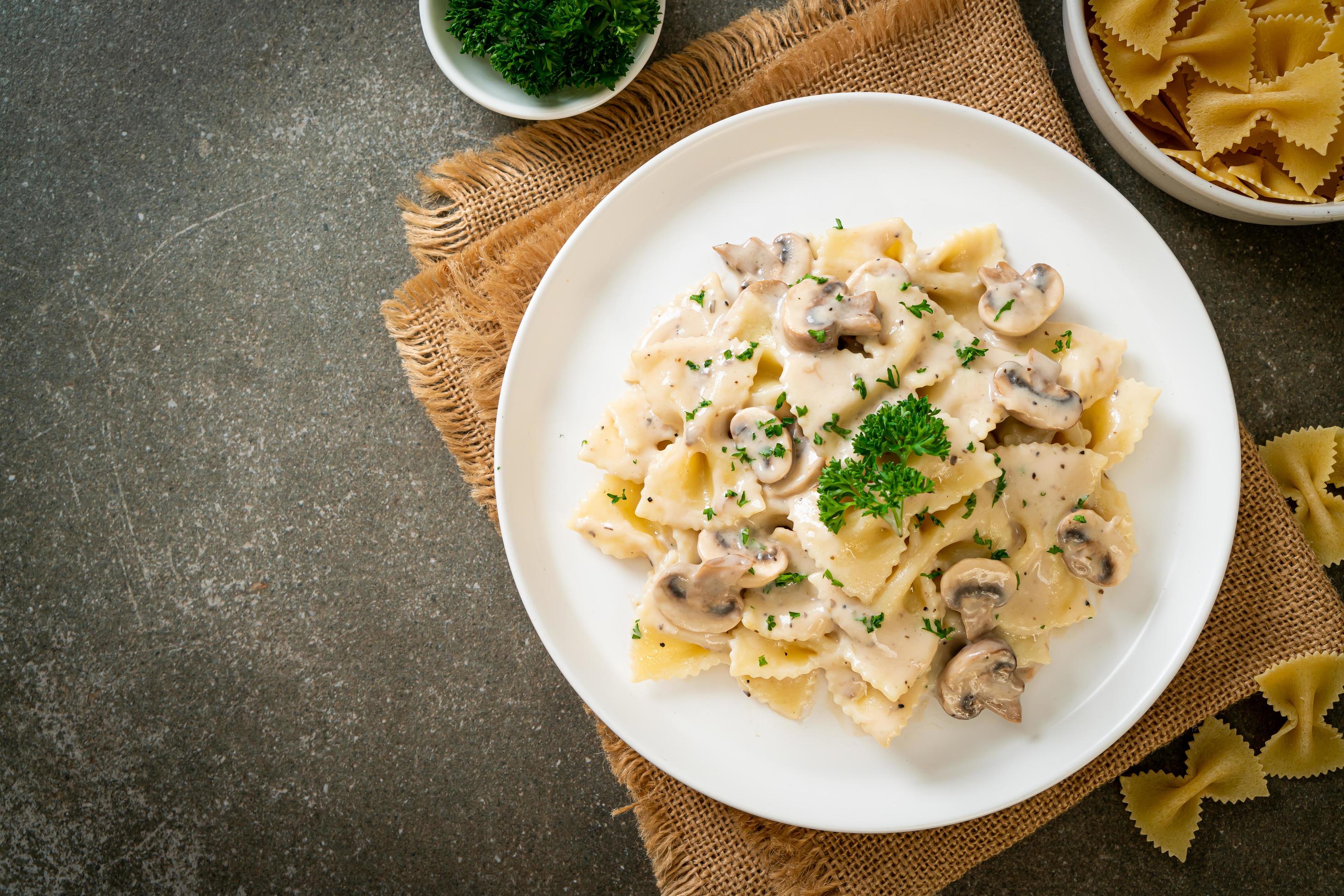 Farfalle pasta with mushroom white cream sauce – Italian food style Stock Free