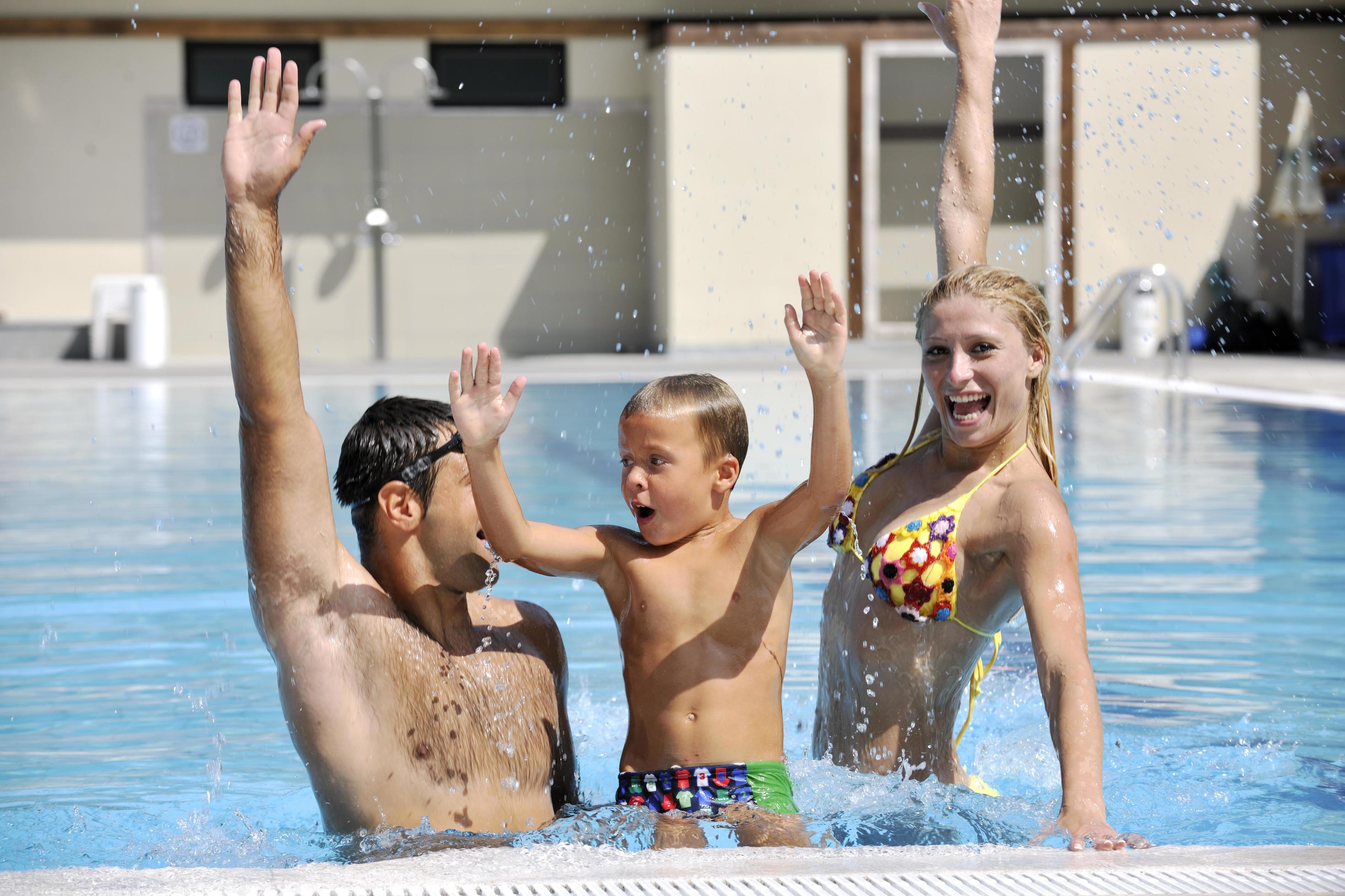 happy young family have fun on swimming pool Stock Free