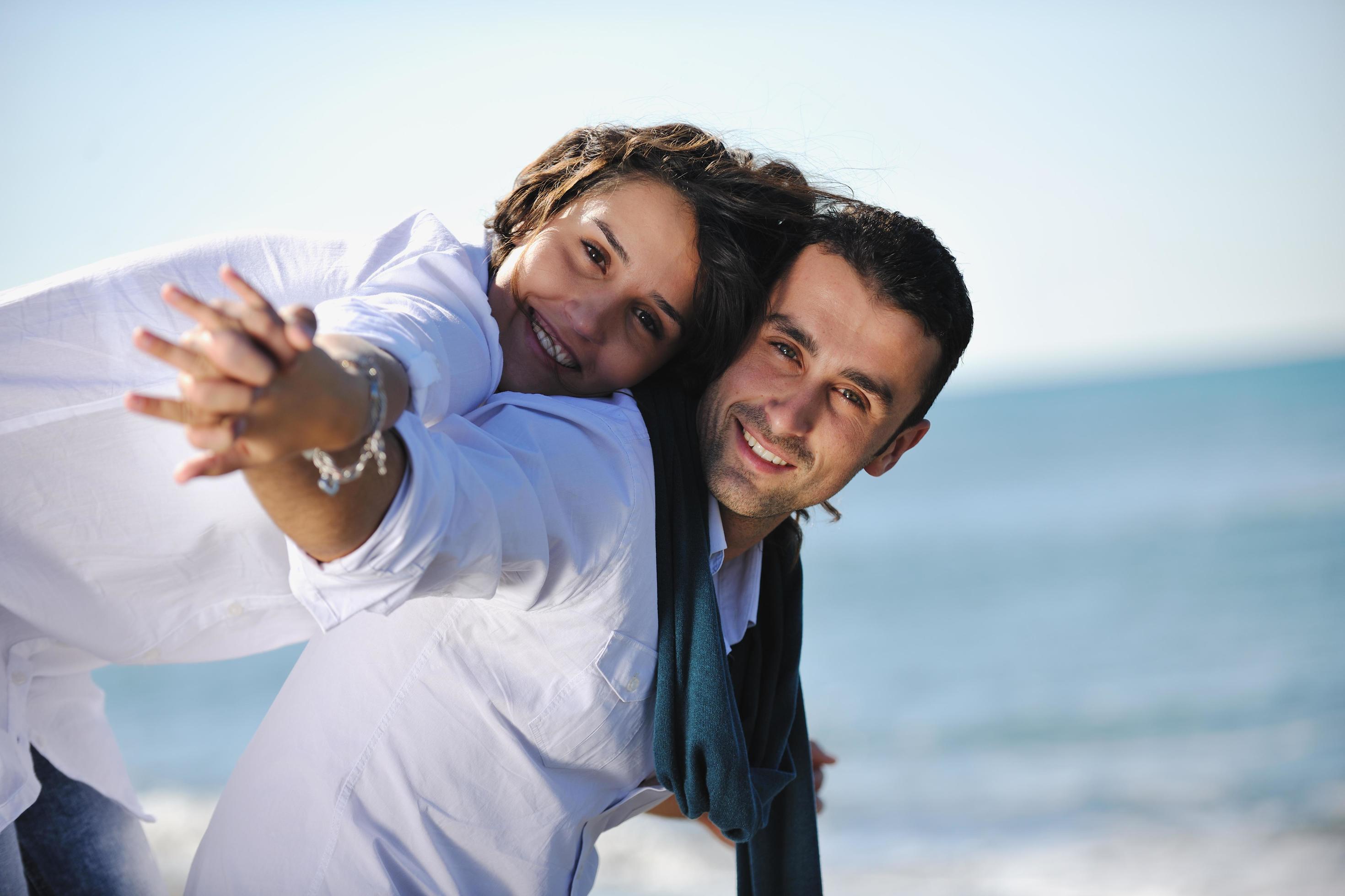 happy young couple have fun at beautiful beach Stock Free