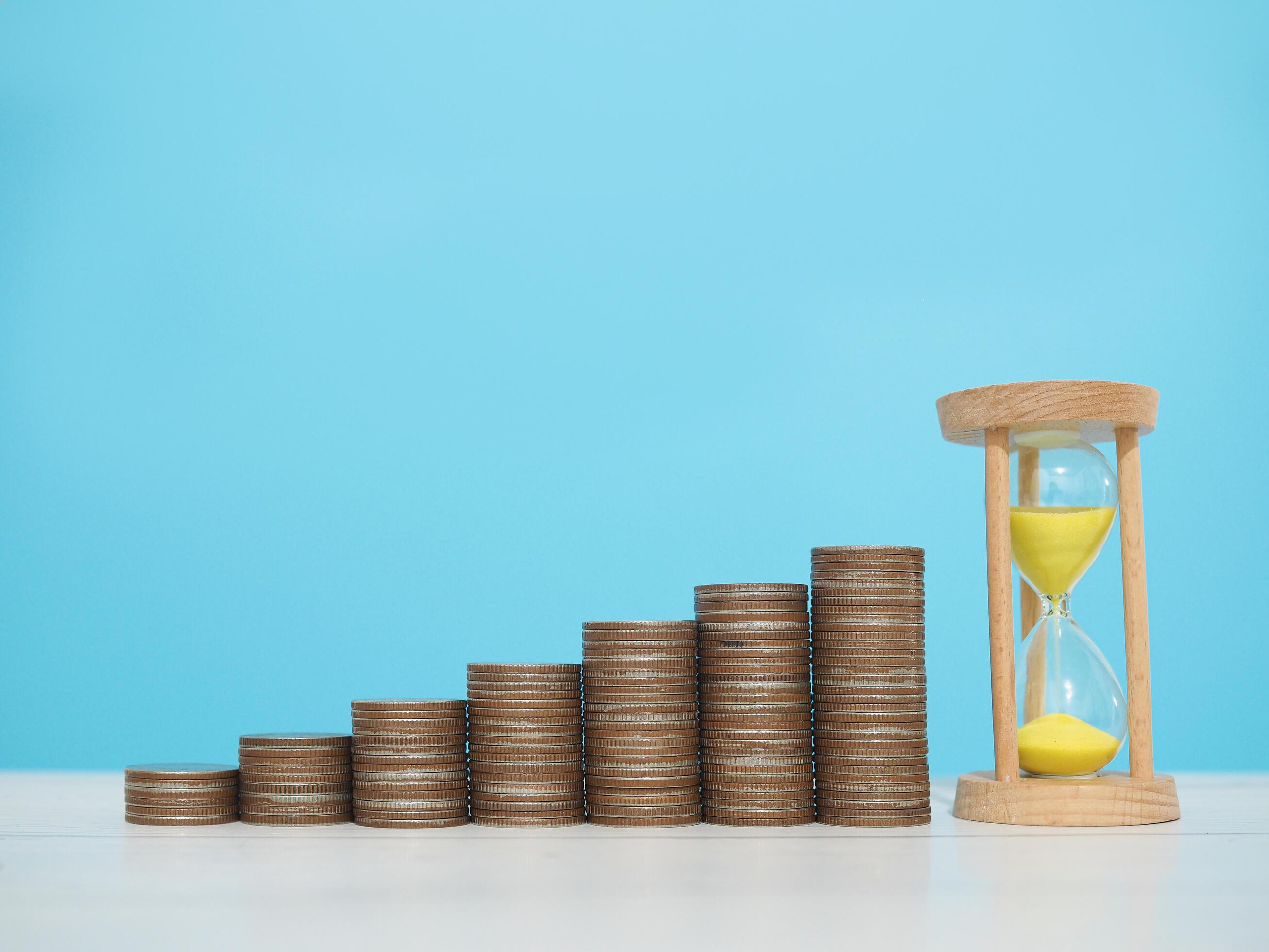 Hourglass and stack of coins. The concept of saving money, manage time to business achievement goal, Financial, Investment and Business growing Stock Free