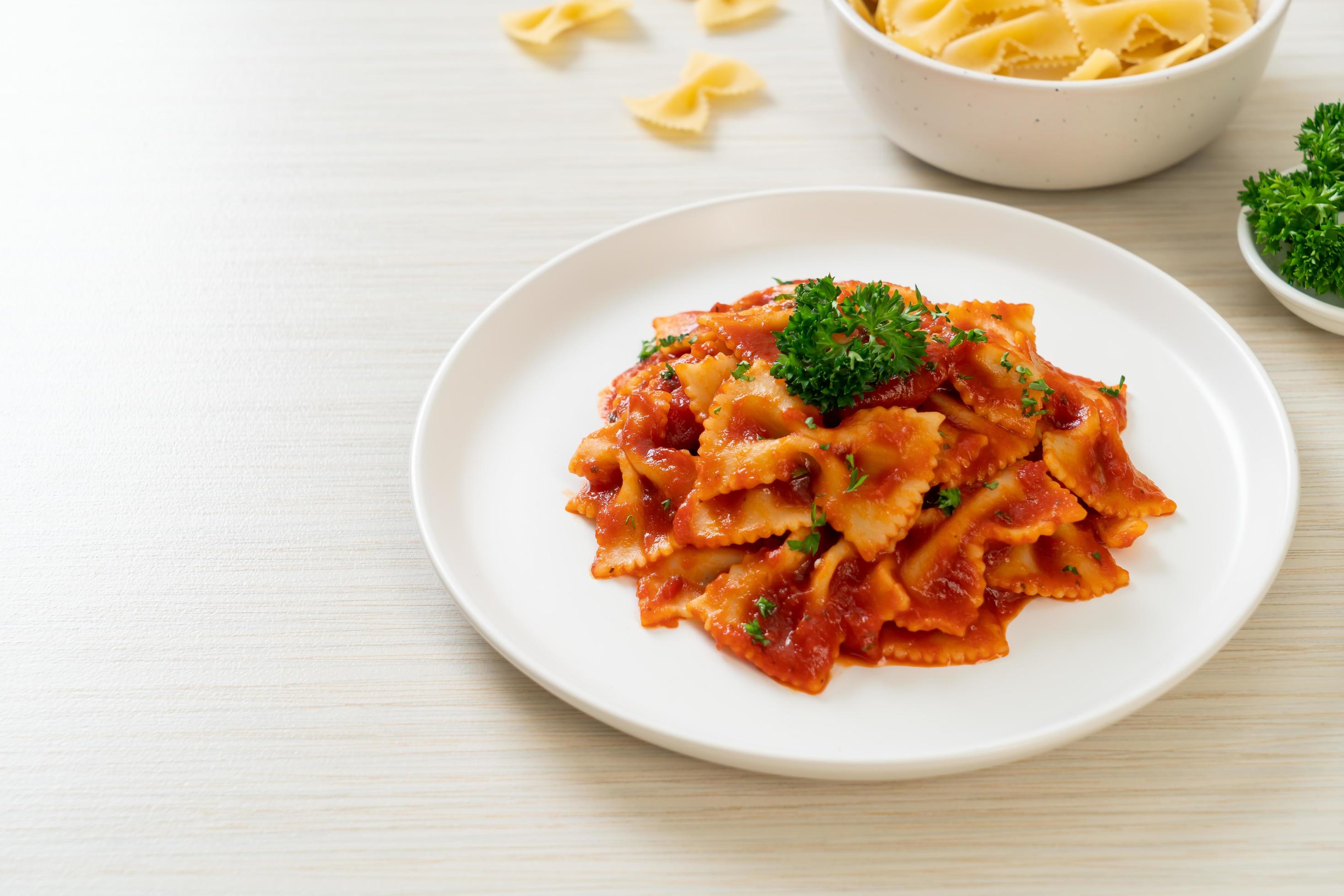 Farfalle pasta in tomato sauce with parsley – Italian food style Stock Free