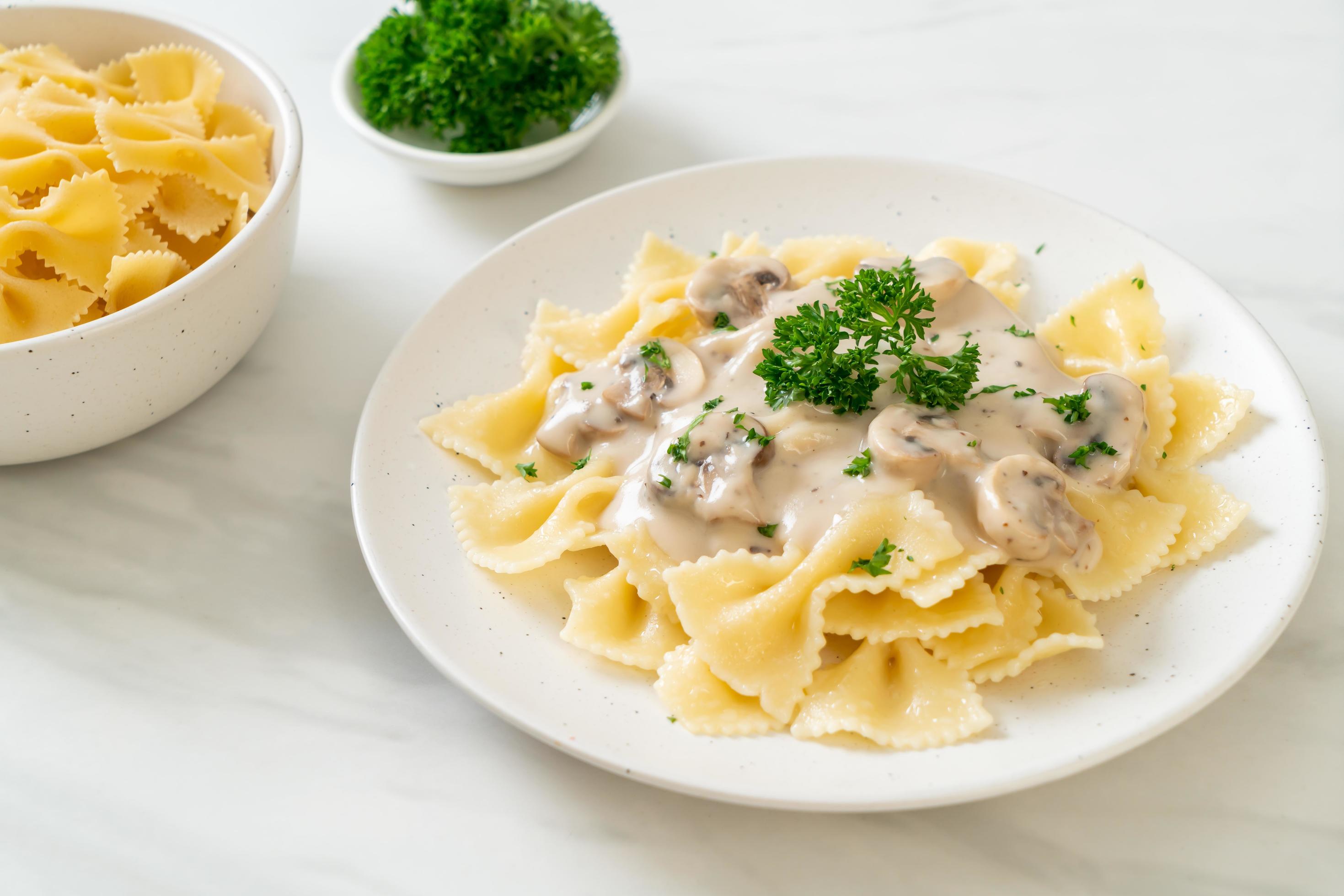 Farfalle pasta with mushroom white cream sauce – Italian food style Stock Free