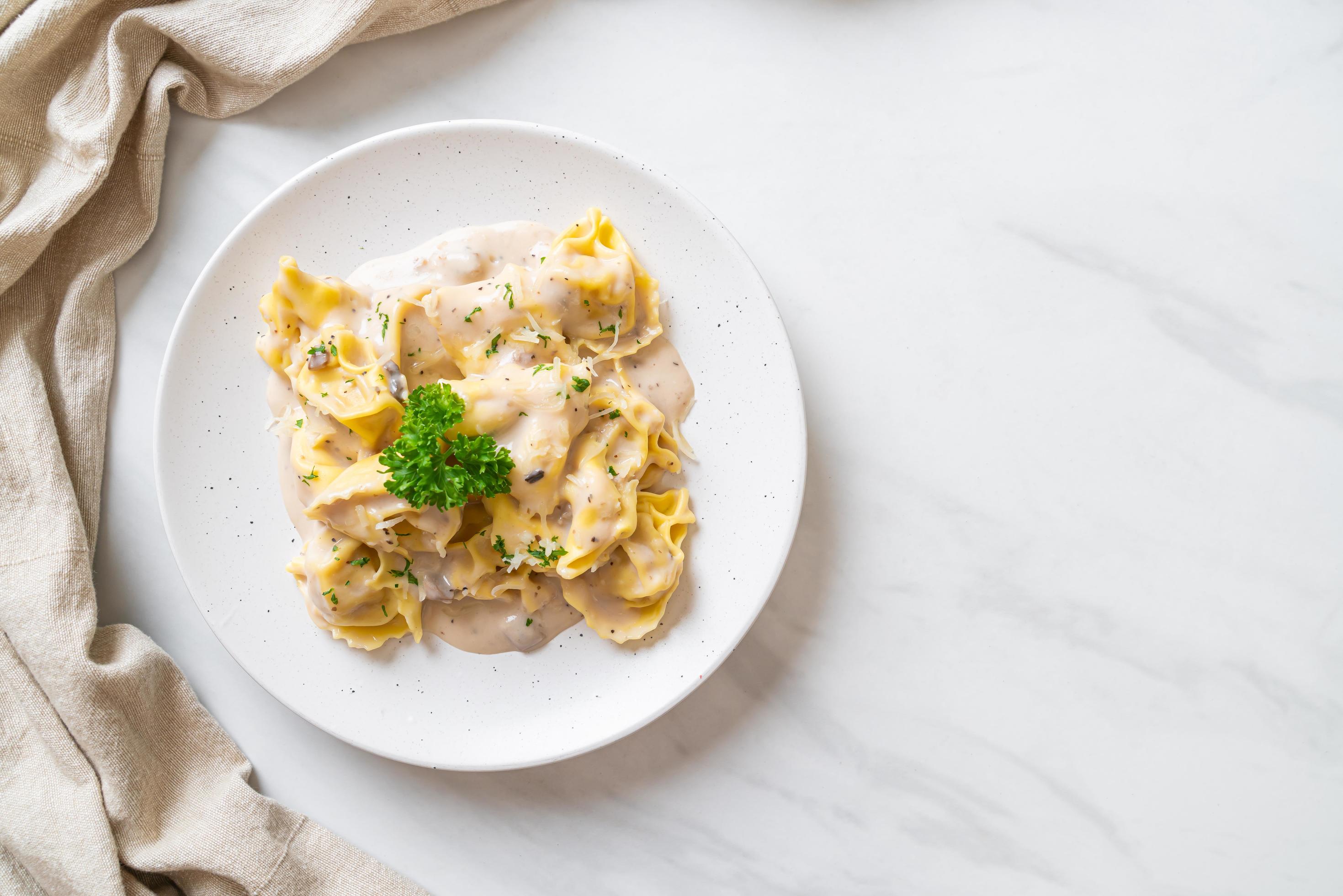 Tortellini pasta with mushroom cream sauce and cheese – Italian food style Stock Free