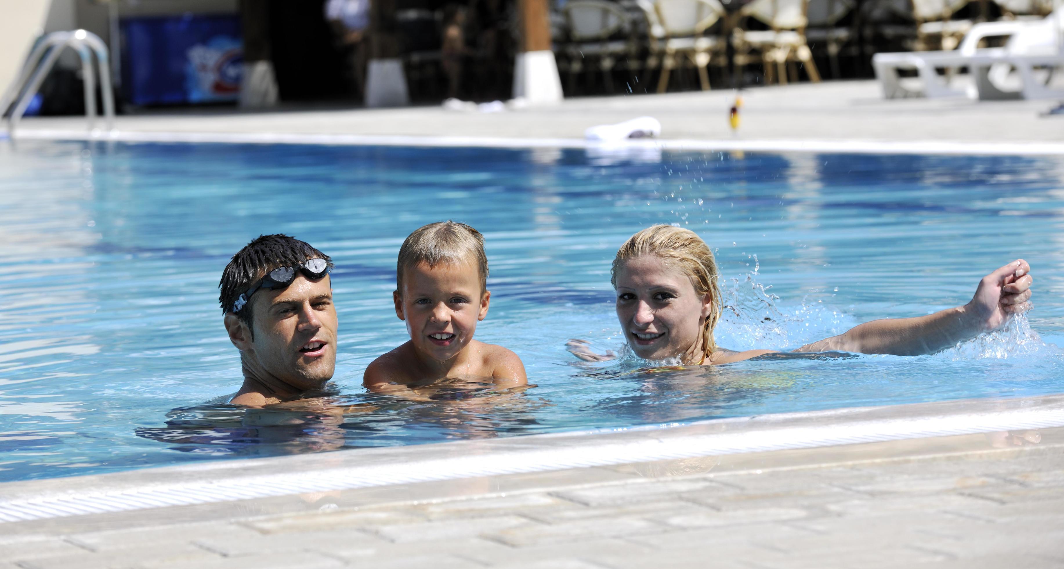 happy young family have fun on swimming pool Stock Free