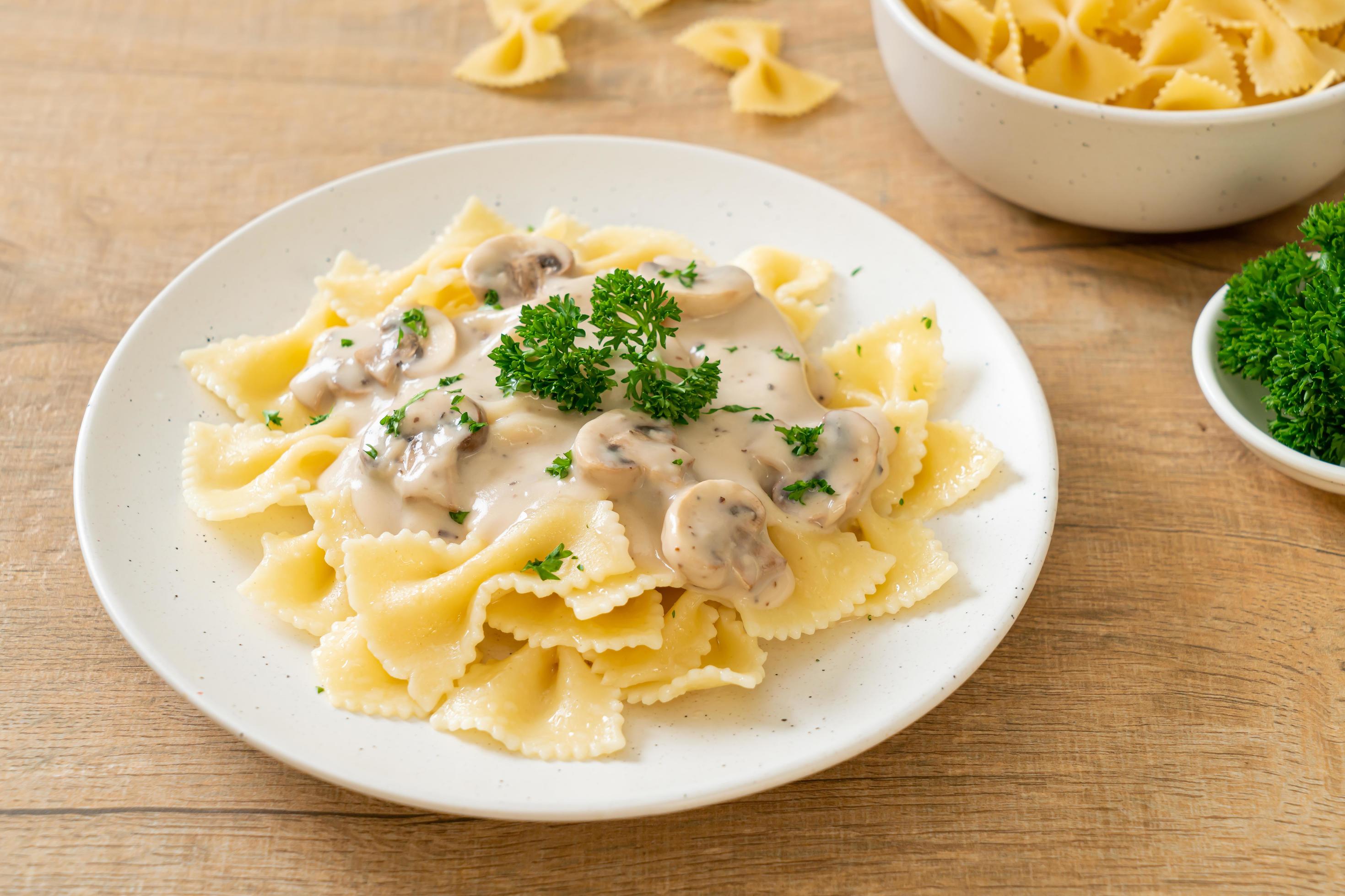 Farfalle pasta with mushroom white cream sauce – Italian food style Stock Free