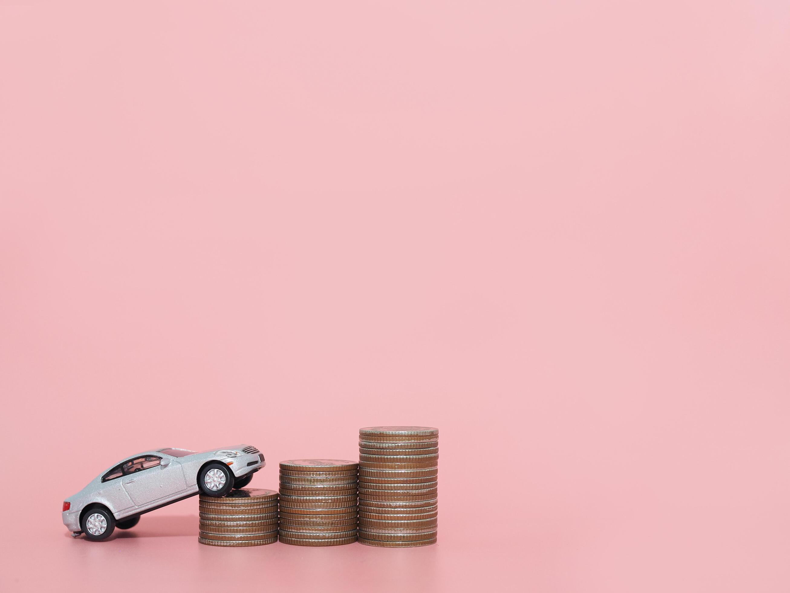 Toy car and stack of coins. The concept of saving money and manage to success transport business Stock Free