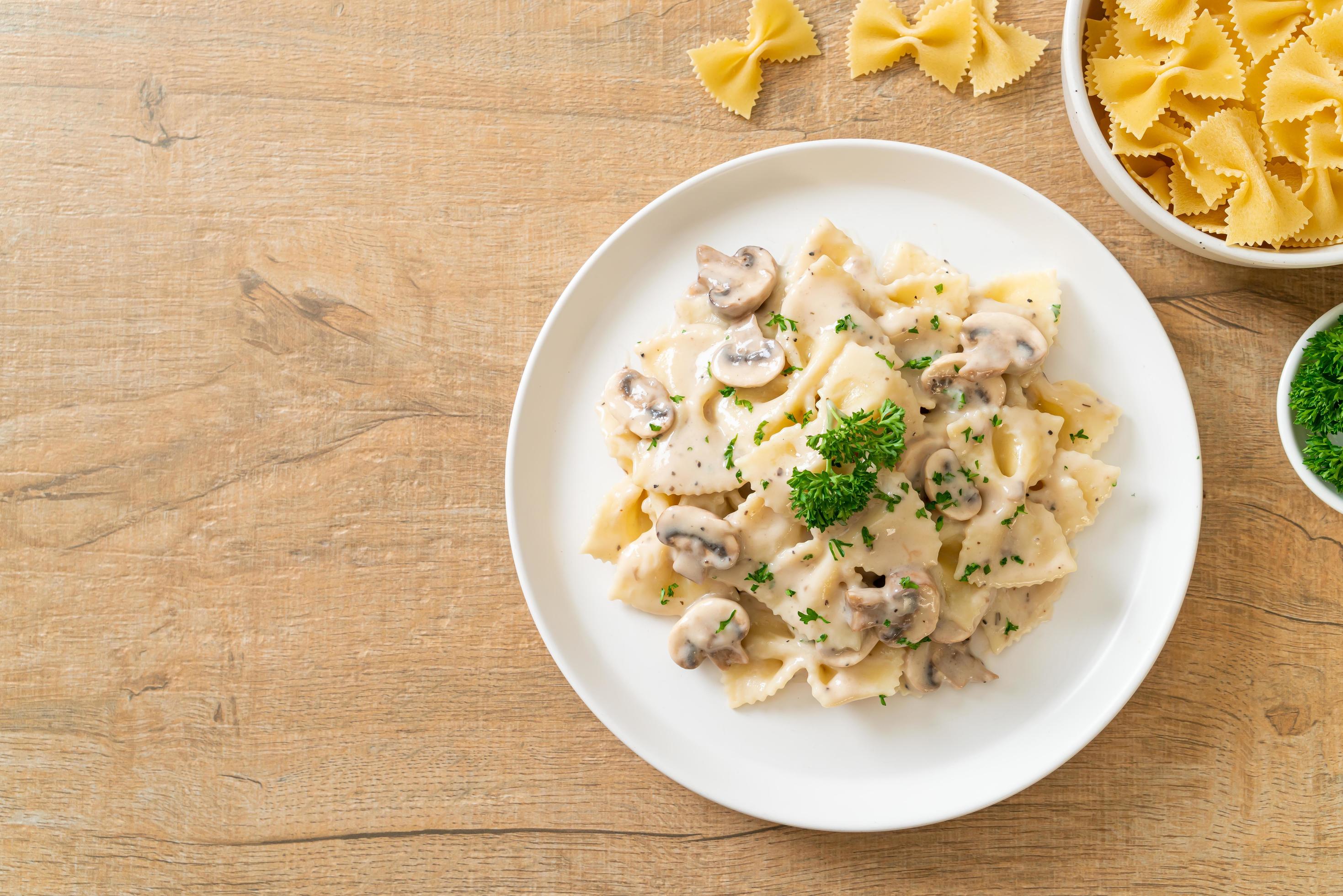 Farfalle pasta with mushroom white cream sauce – Italian food style Stock Free