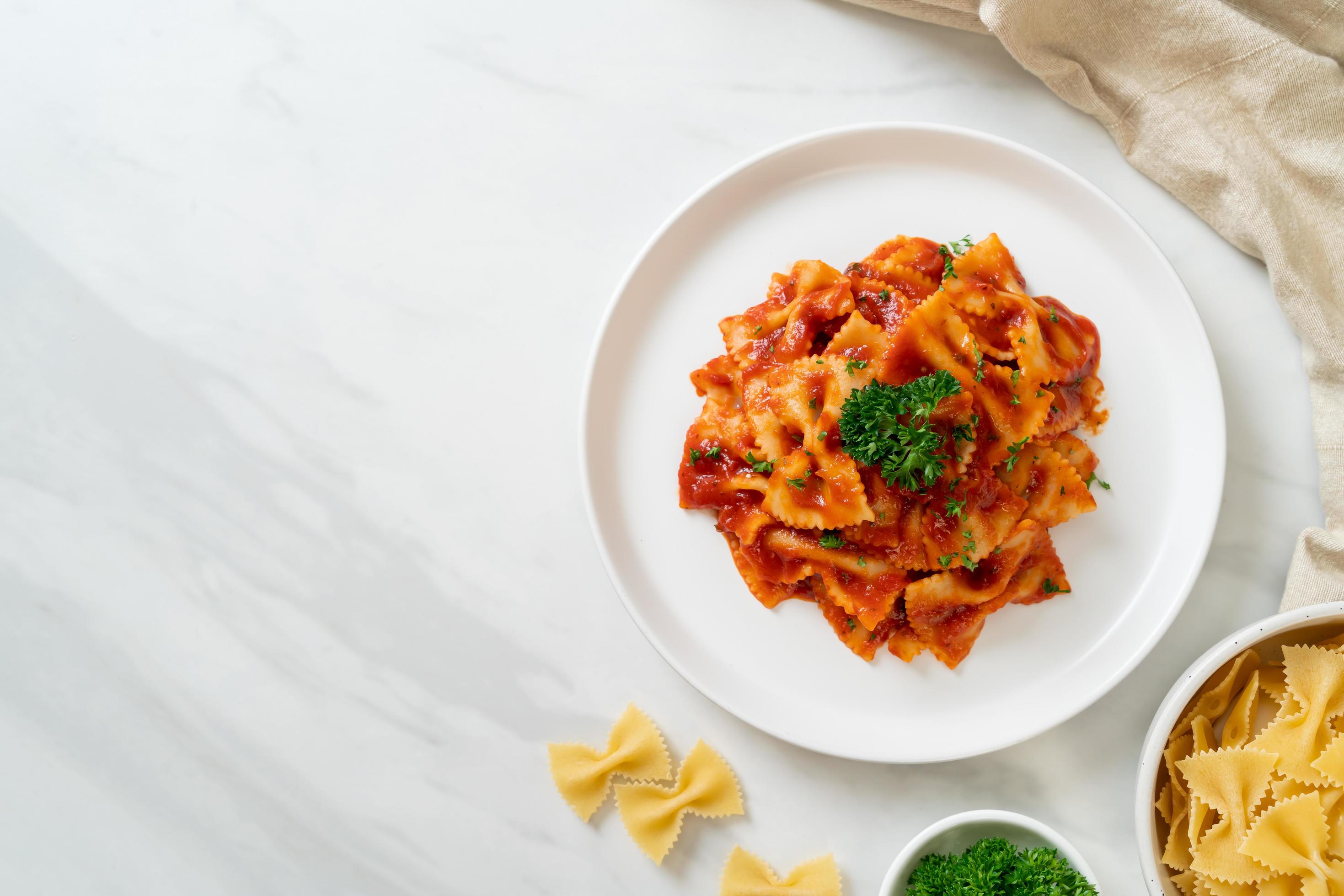 Farfalle pasta in tomato sauce with parsley – Italian food style Stock Free