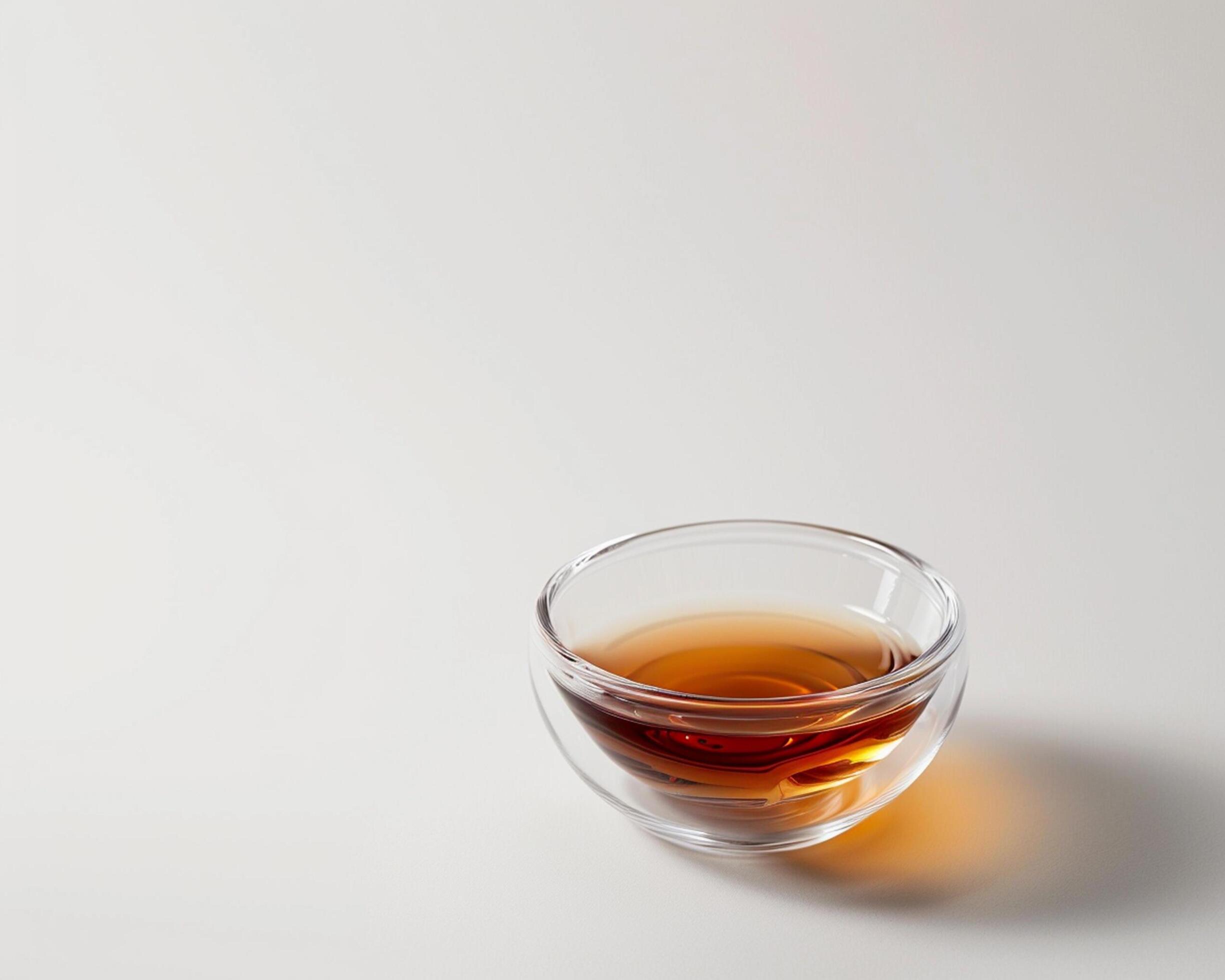 a glass cup of tea on a white surface Stock Free