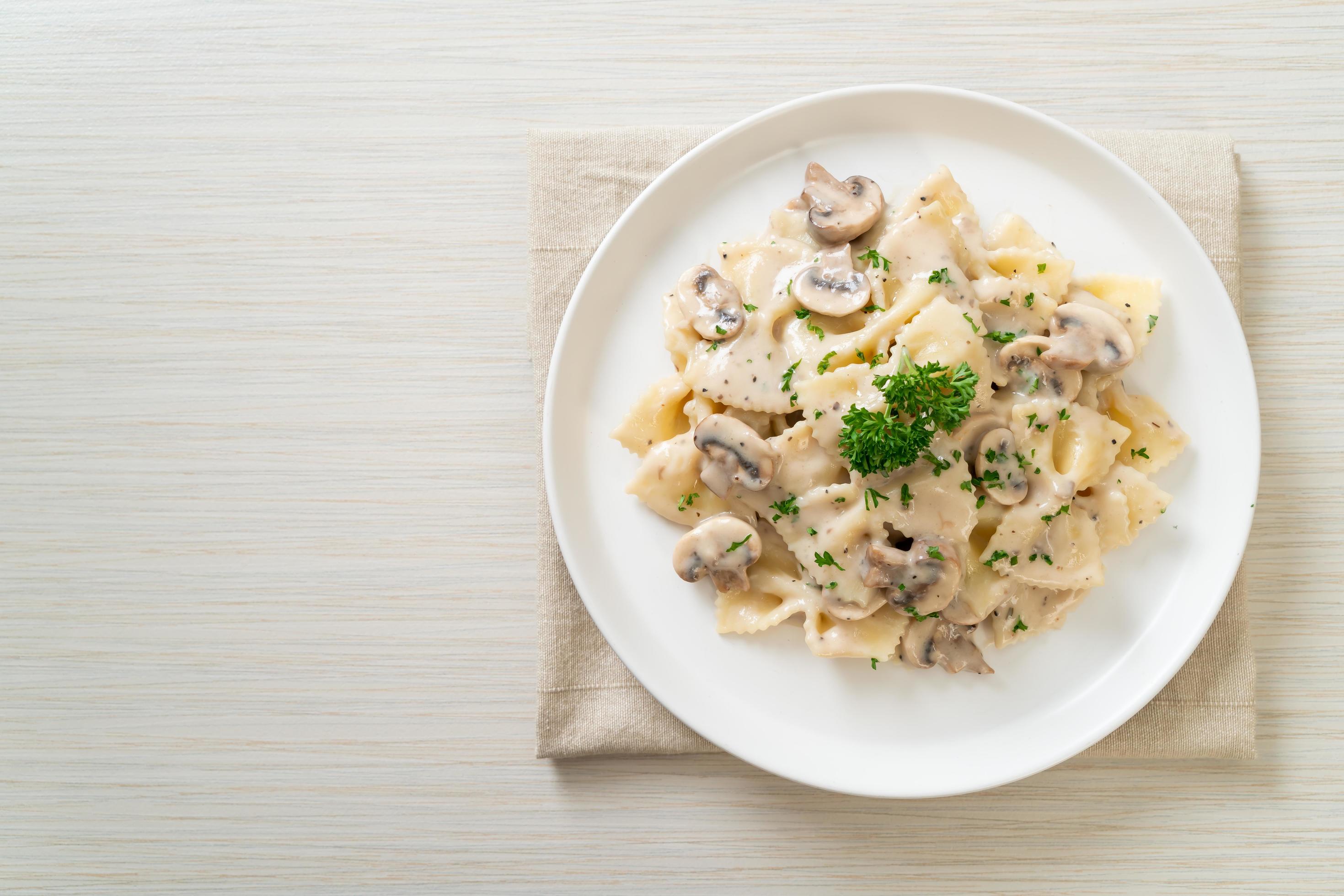 Farfalle pasta with mushroom white cream sauce – Italian food style Stock Free