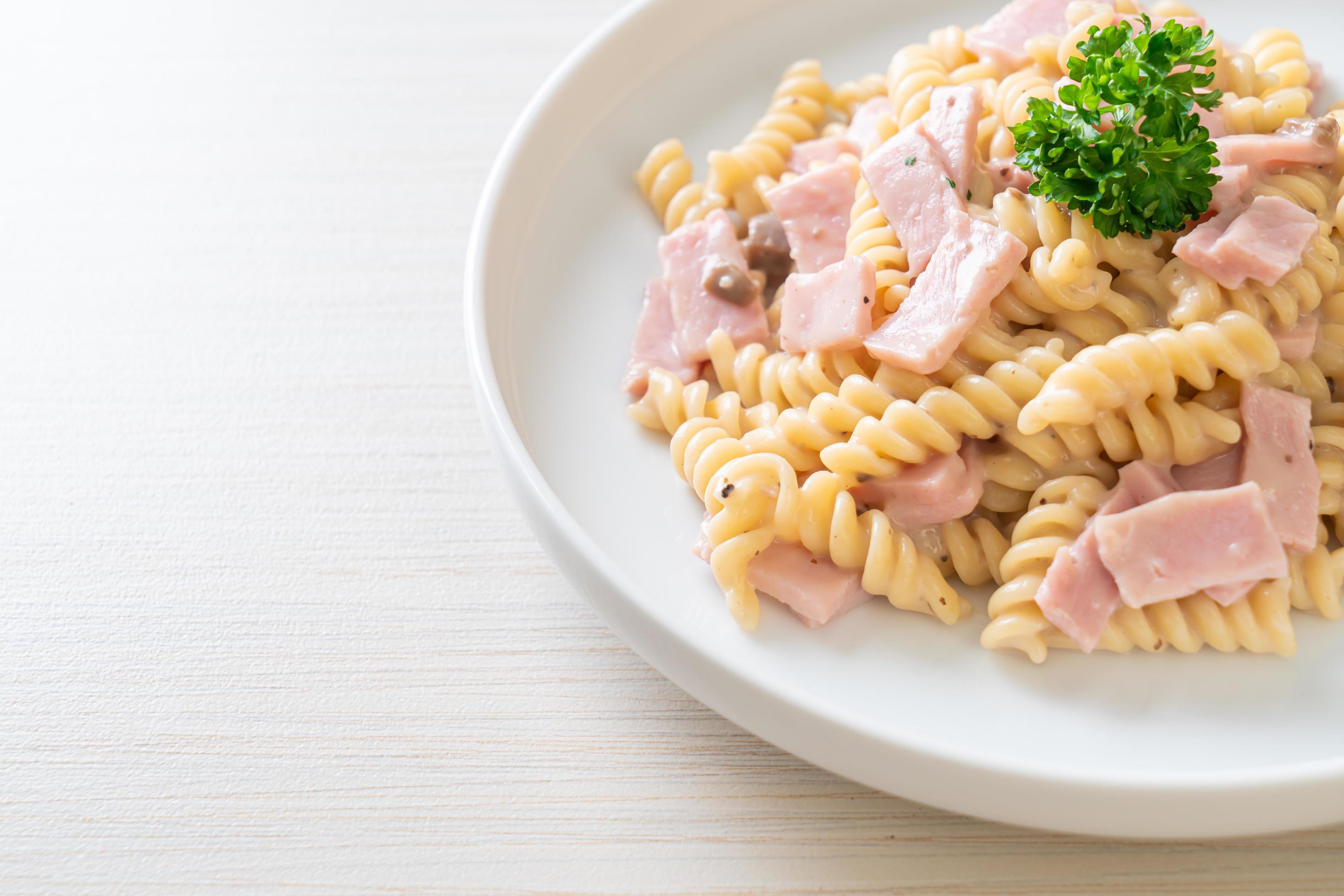 Spirali or spiral pasta mushroom cream sauce with ham – Italian food style Stock Free