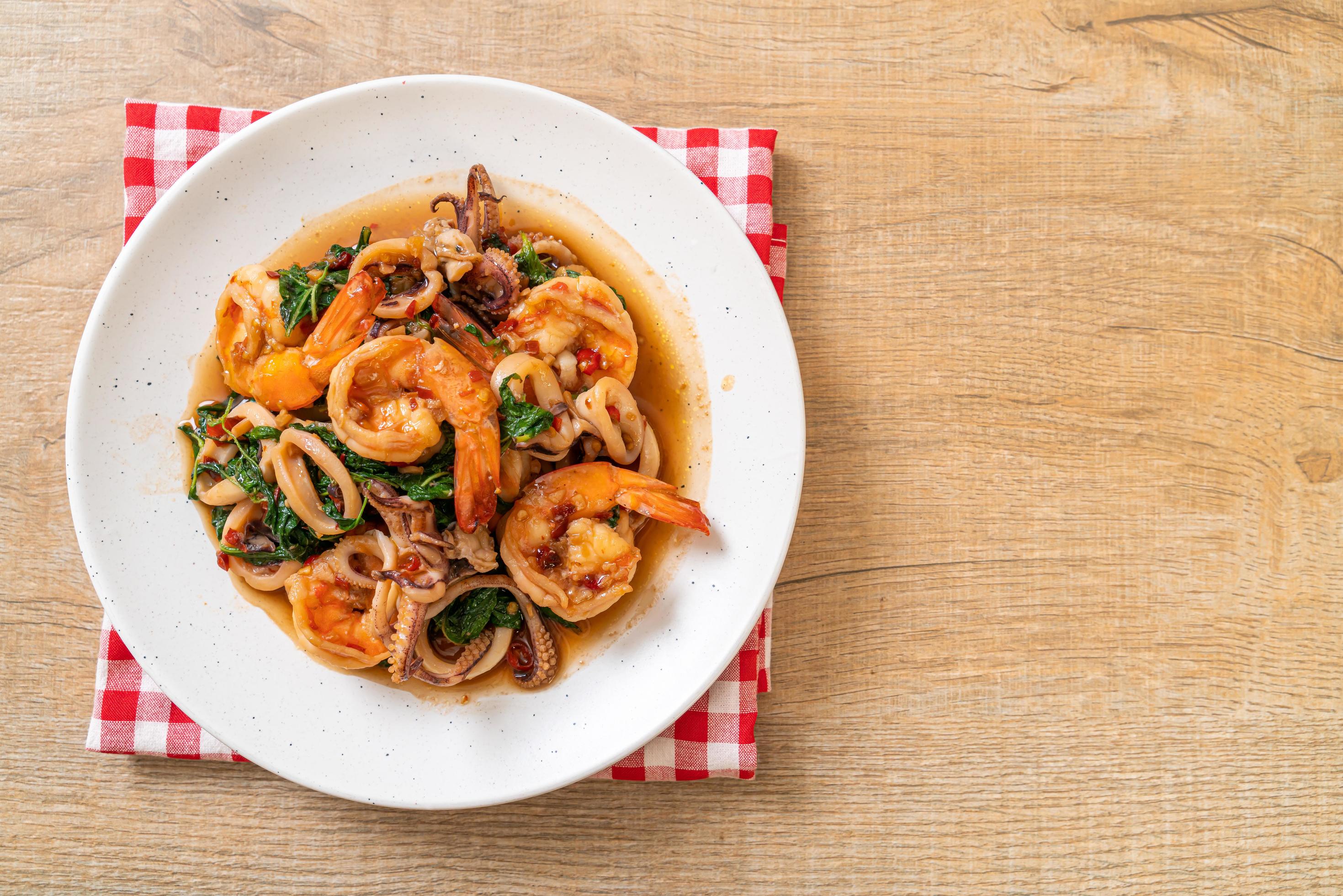 Stir-fried seafood of shrimps and squid with Thai basil – Asian food style Stock Free