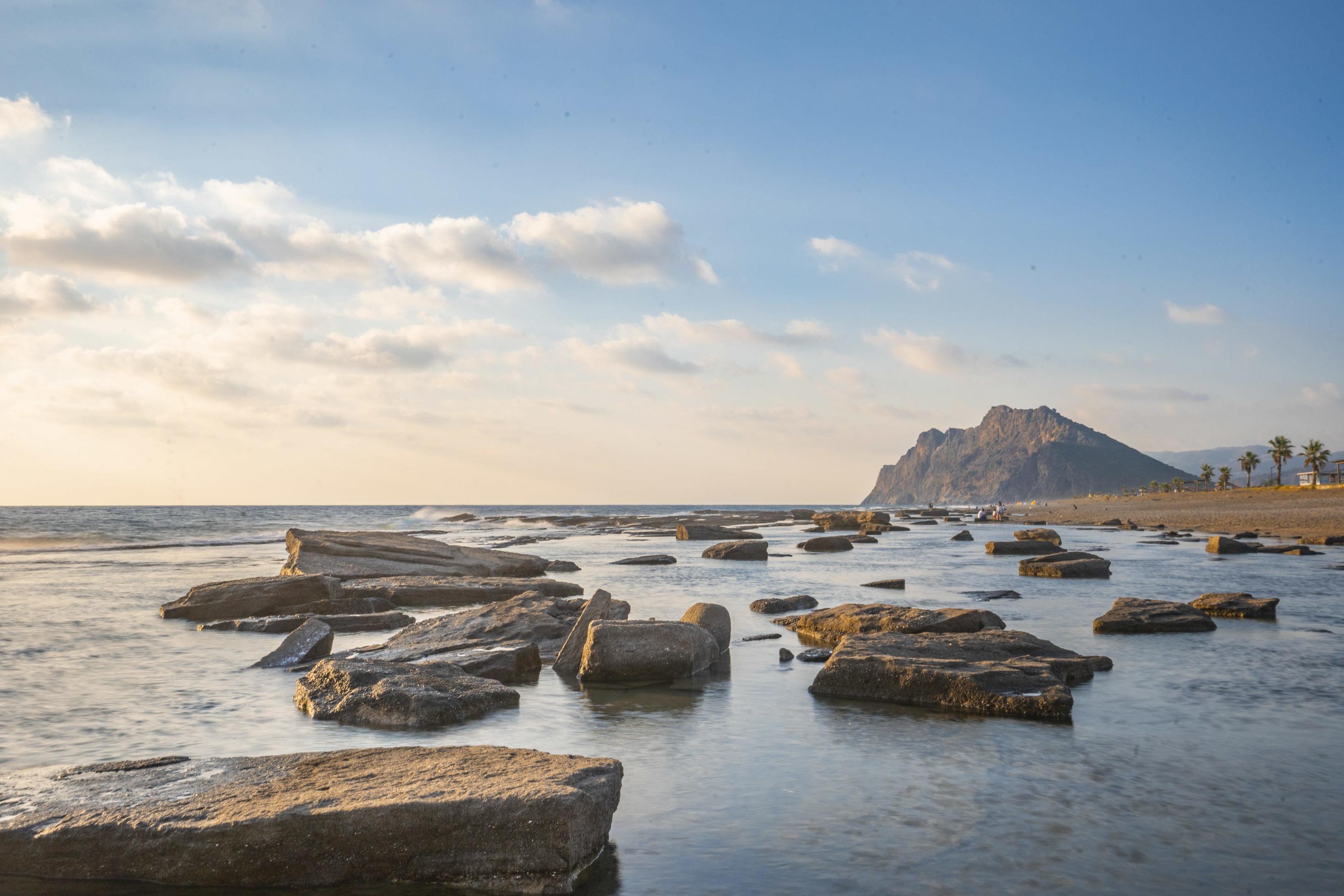 Long exposure photography of waves and pebbles on Beach in the sunset Stock Free