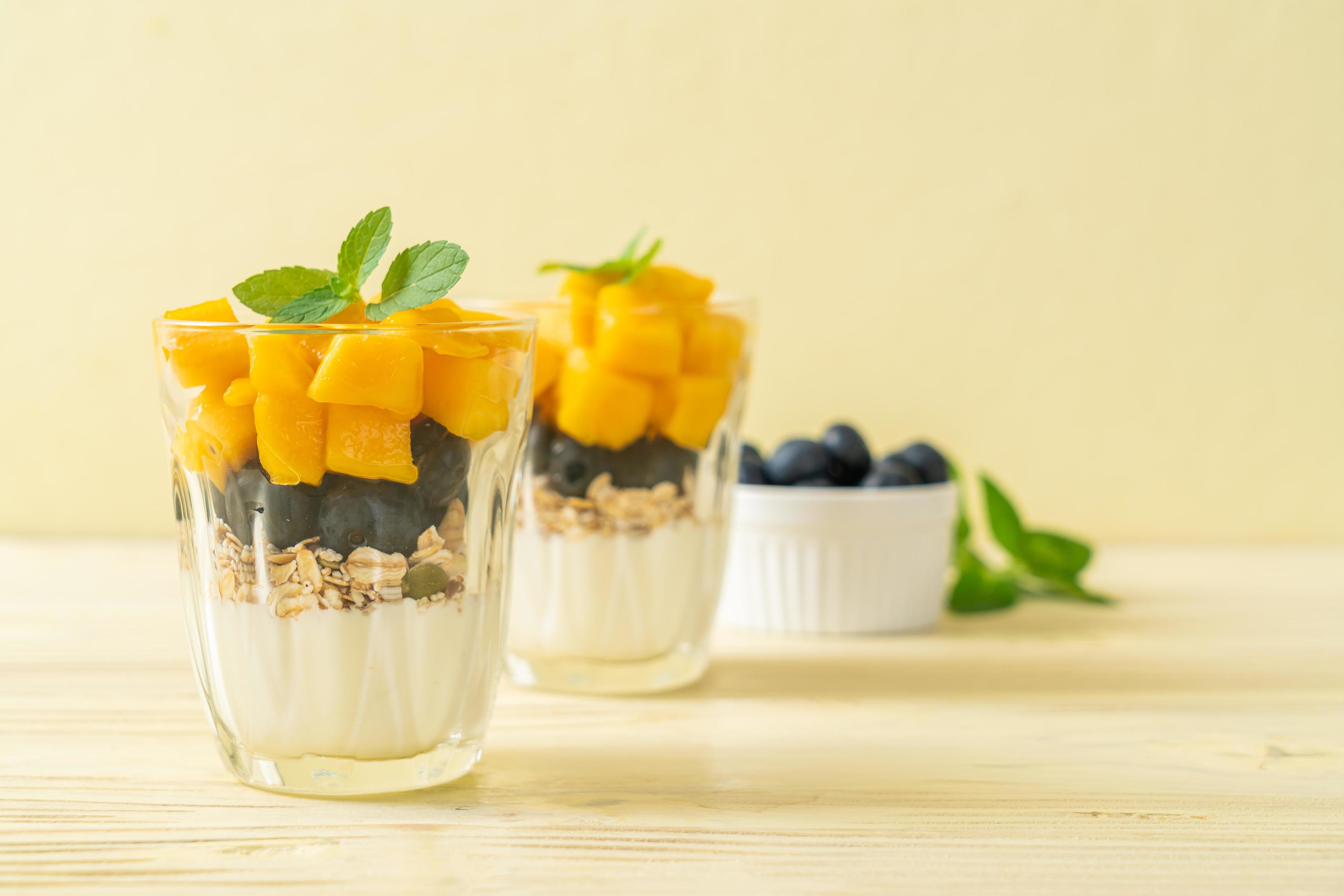 Homemade fresh mango and fresh blueberry with yogurt and granola – healthy food style Stock Free