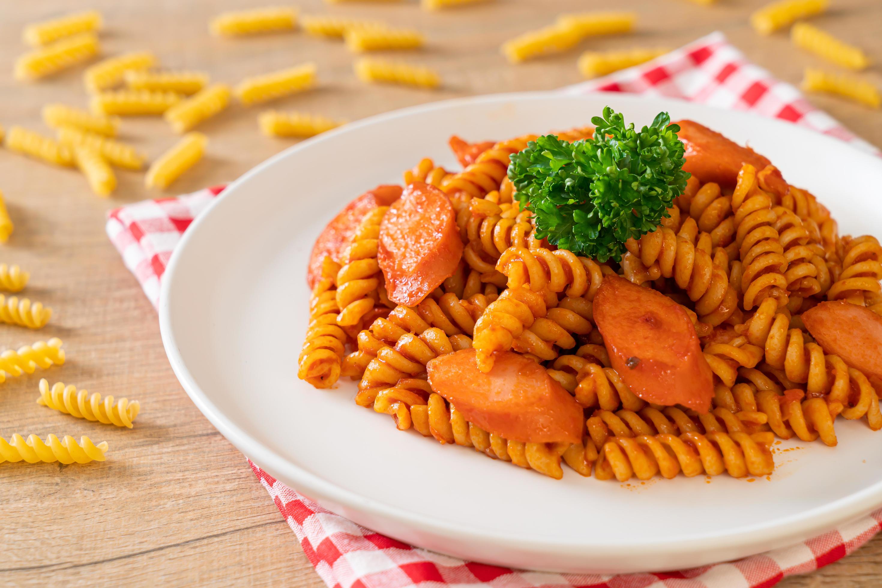 Spiral or spirali pasta with tomato sauce and sausage – Italian food style Stock Free