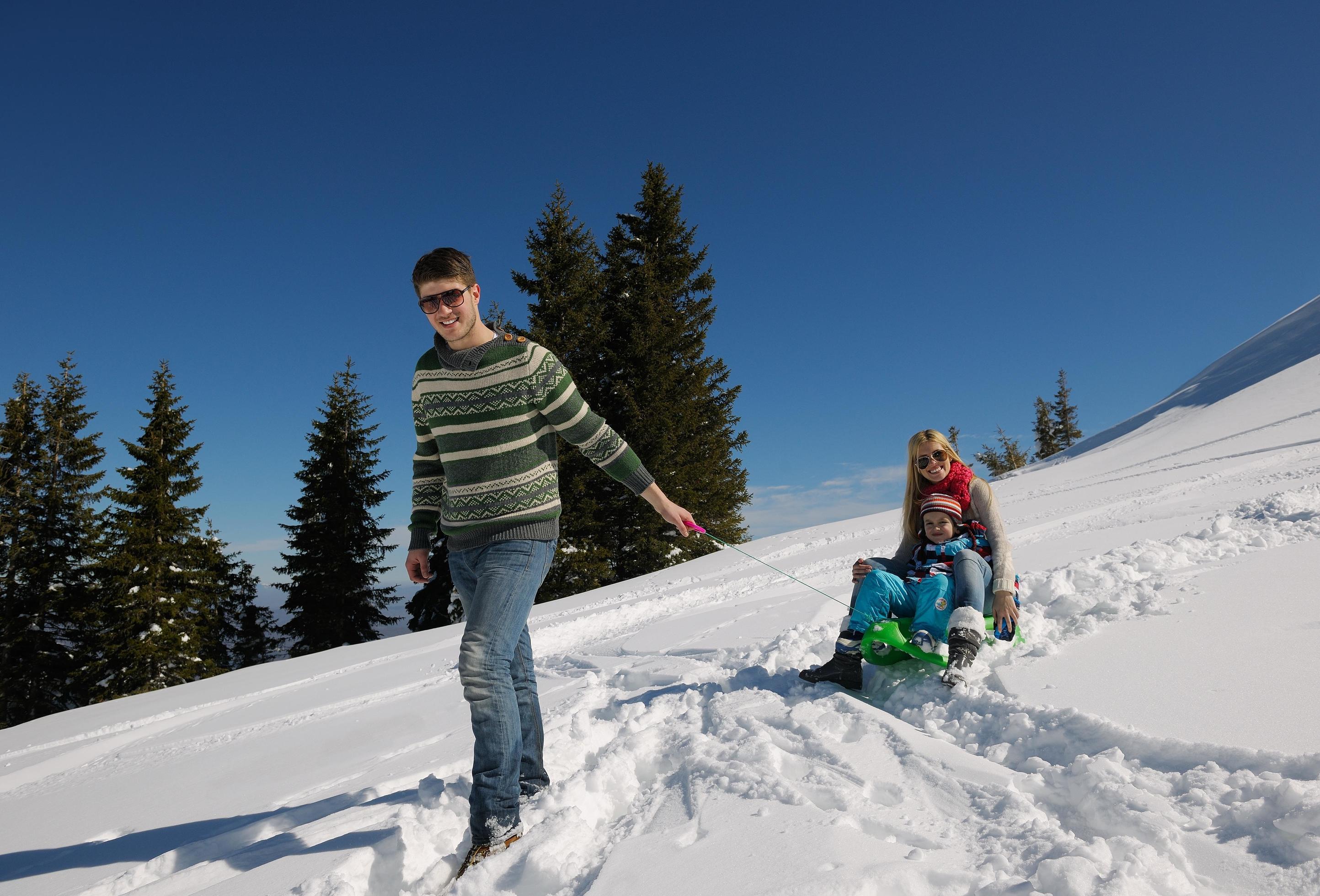 family having fun on fresh snow at winter vacation Stock Free