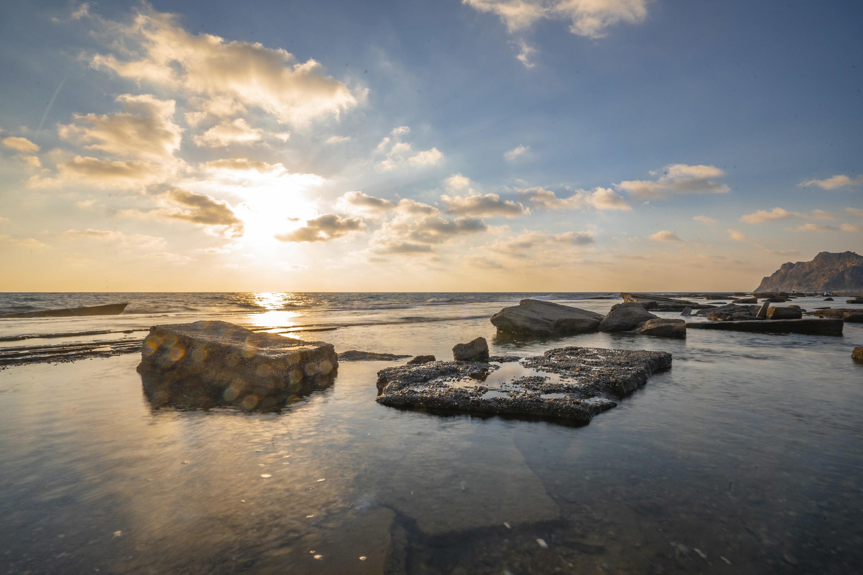 Beautiful view of the sea with the sun shining in a blue sky in the background Stock Free