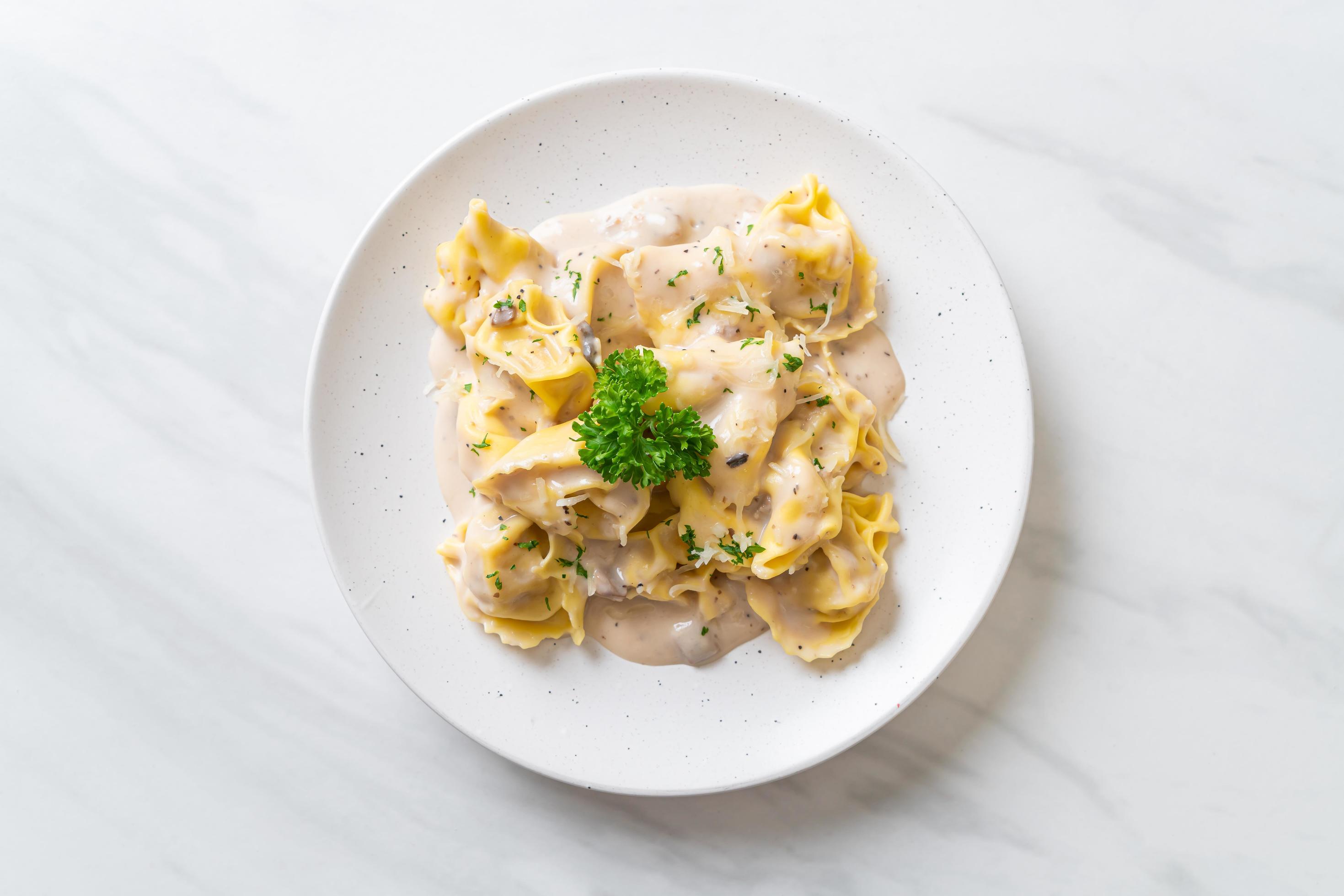 Tortellini pasta with mushroom cream sauce and cheese – Italian food style Stock Free