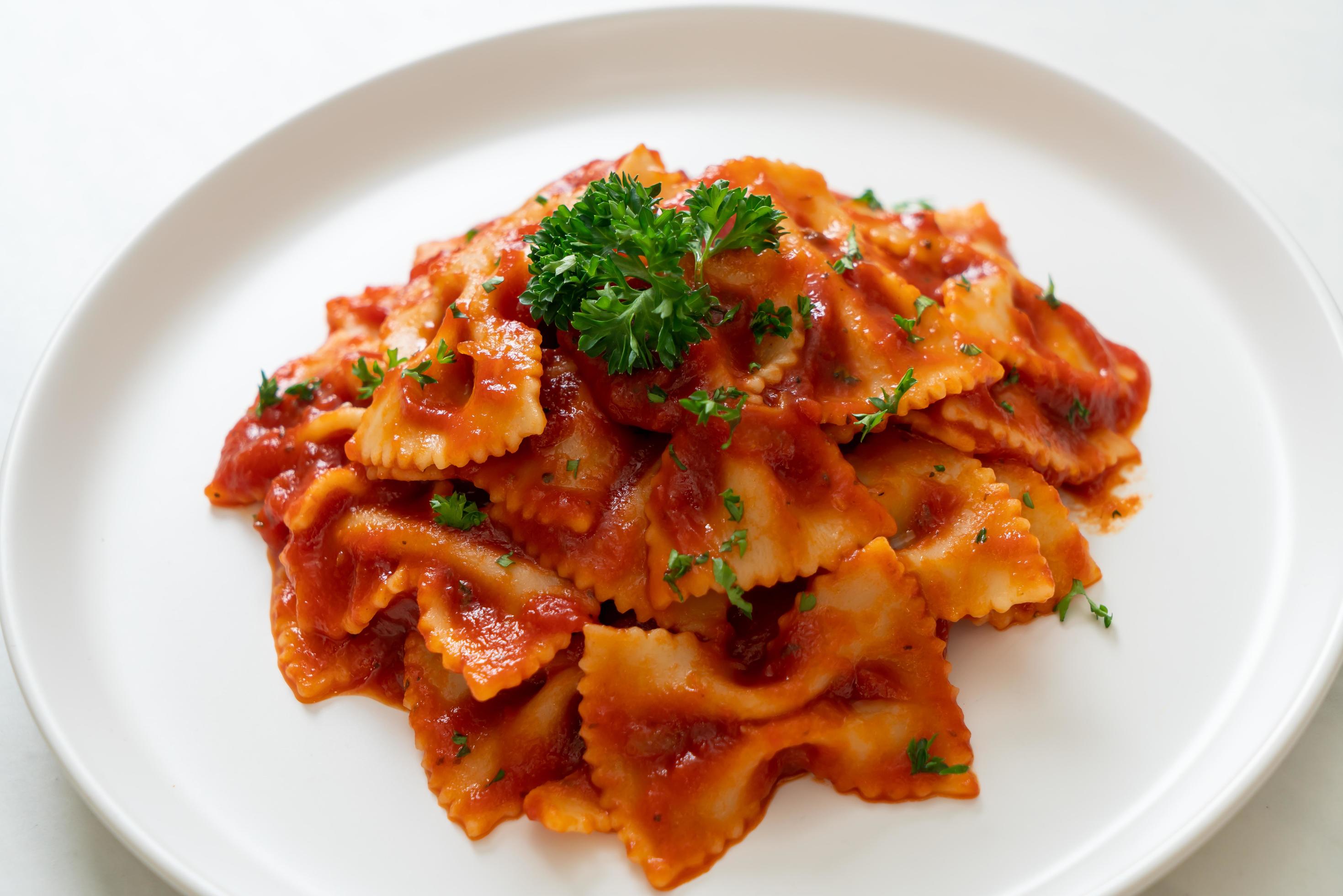 Farfalle pasta in tomato sauce with parsley – Italian food style Stock Free