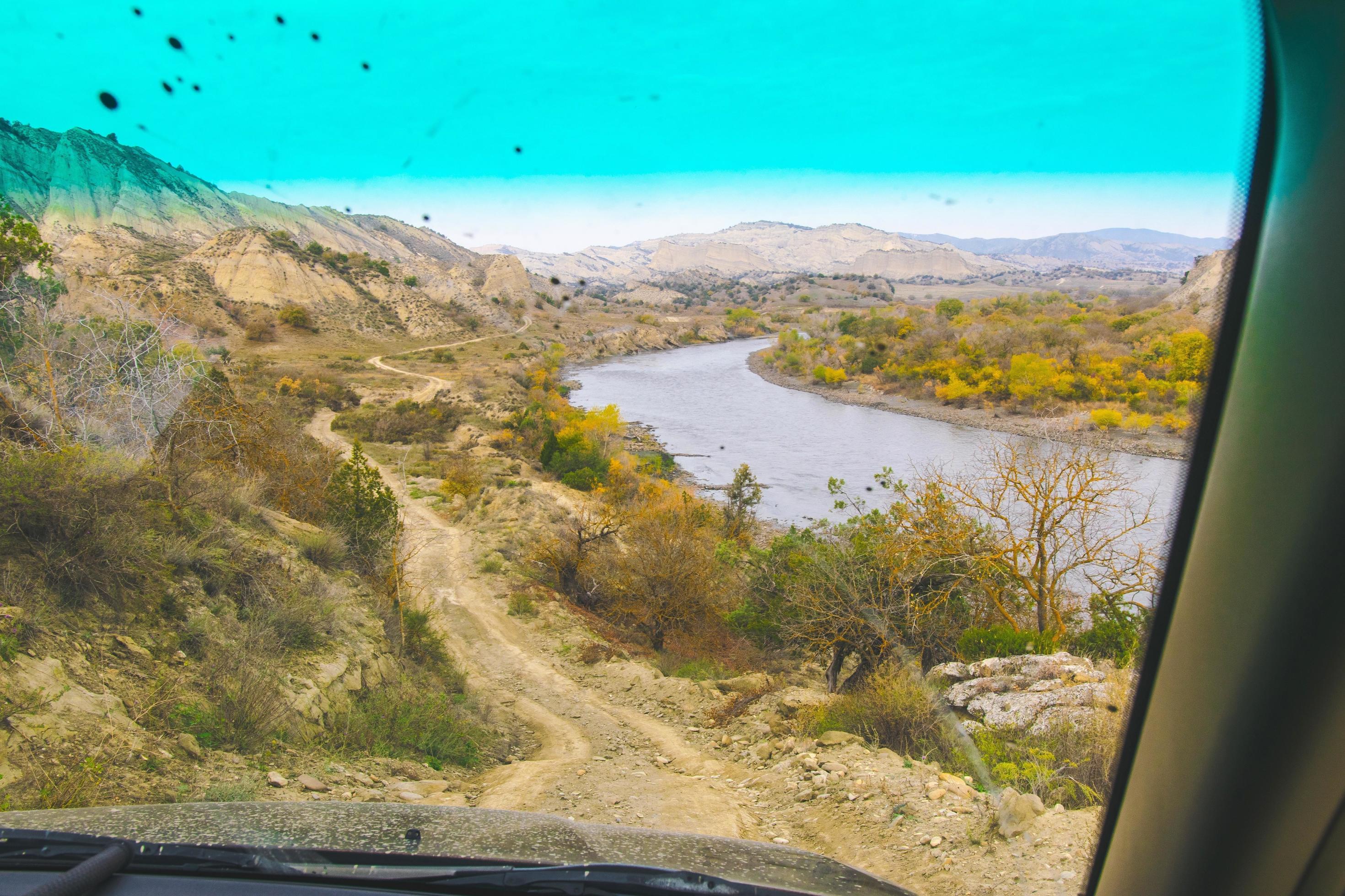 Passenger view from the window of gravel road and river in VAshlovani protected areas. 4wd tours Georgia Stock Free