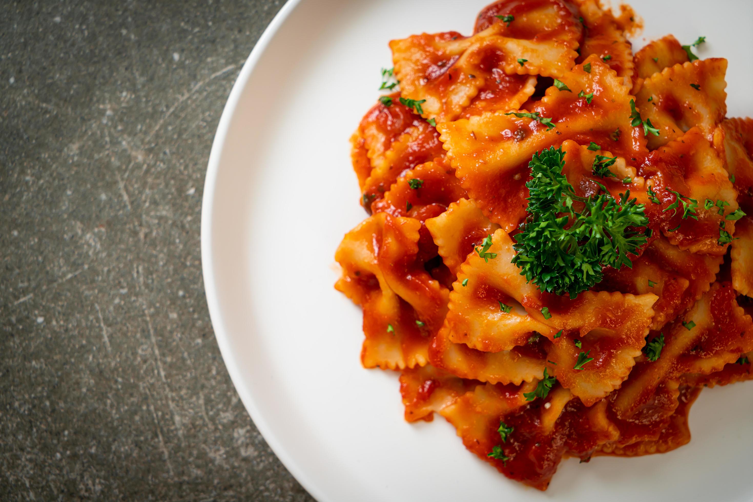 Farfalle pasta in tomato sauce with parsley – Italian food style Stock Free