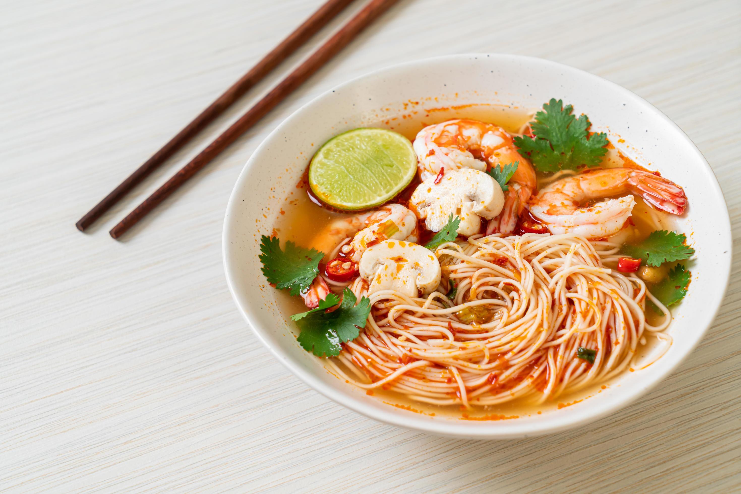 
									Noodles with spicy soup and shrimps in white bowl, or Tom Yum Kung – Asian food style Stock Free