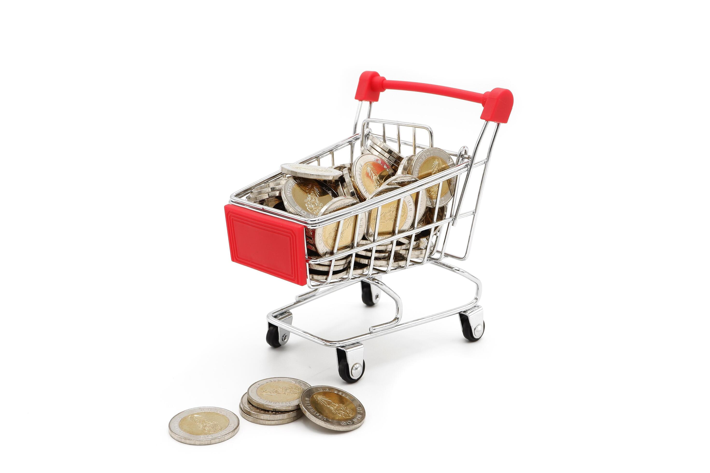 Red miniature shopping cart filled with new 10 Thai Baht coins, isolated on white background. Business concept. Stock Free