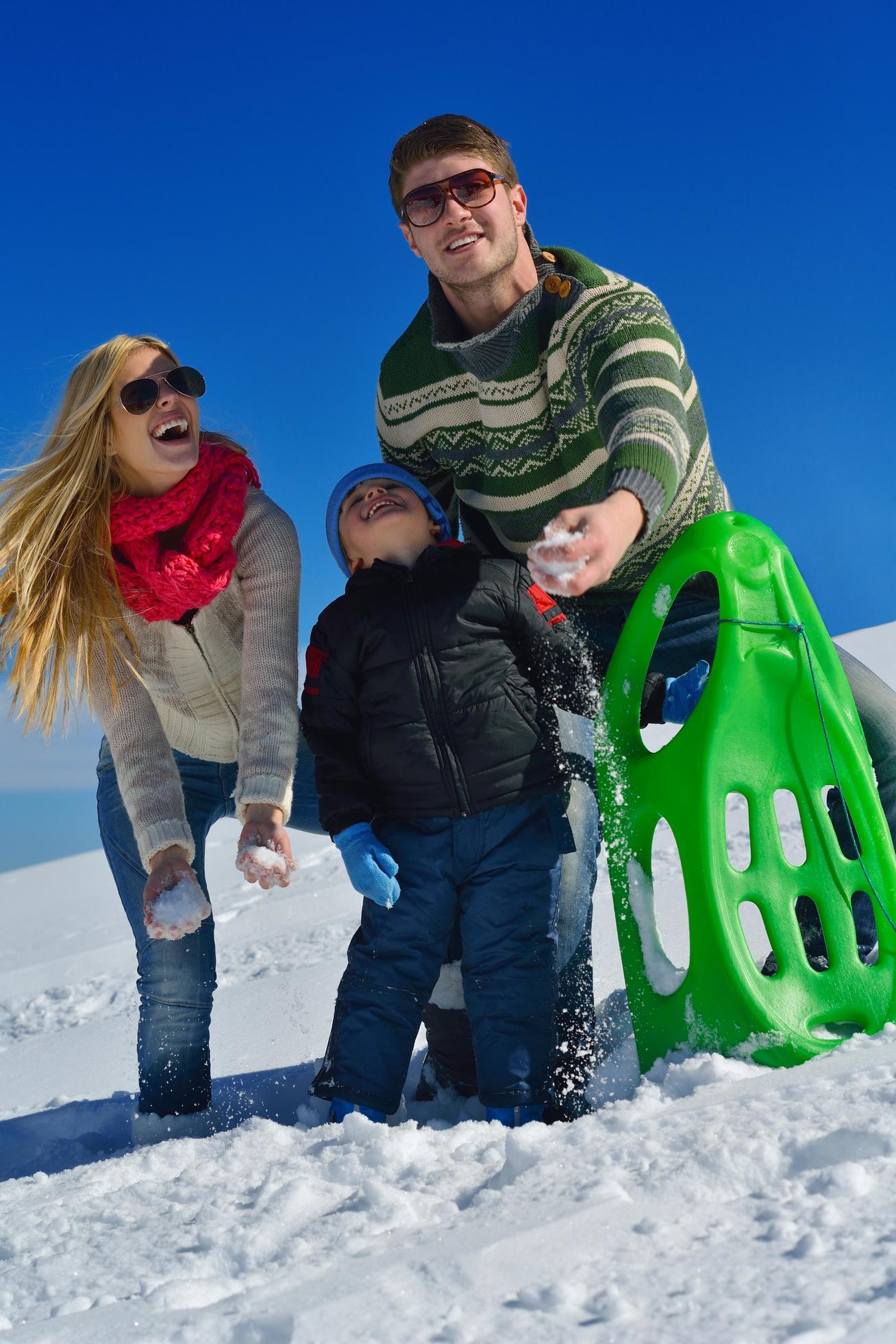 family having fun on fresh snow at winter vacation Stock Free