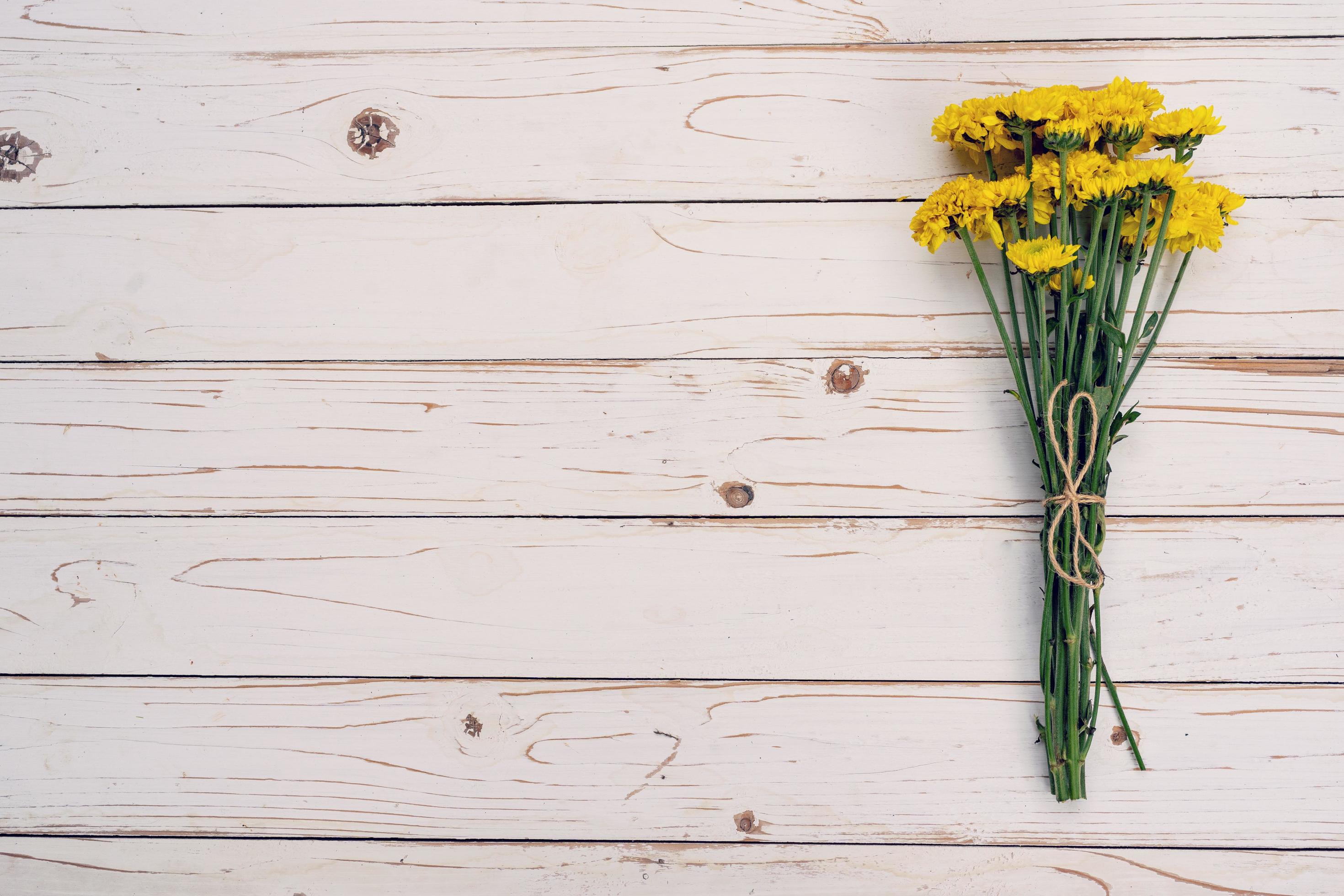 Yellow flowers of bouquet, top view on white wooden background texture with copy space Stock Free