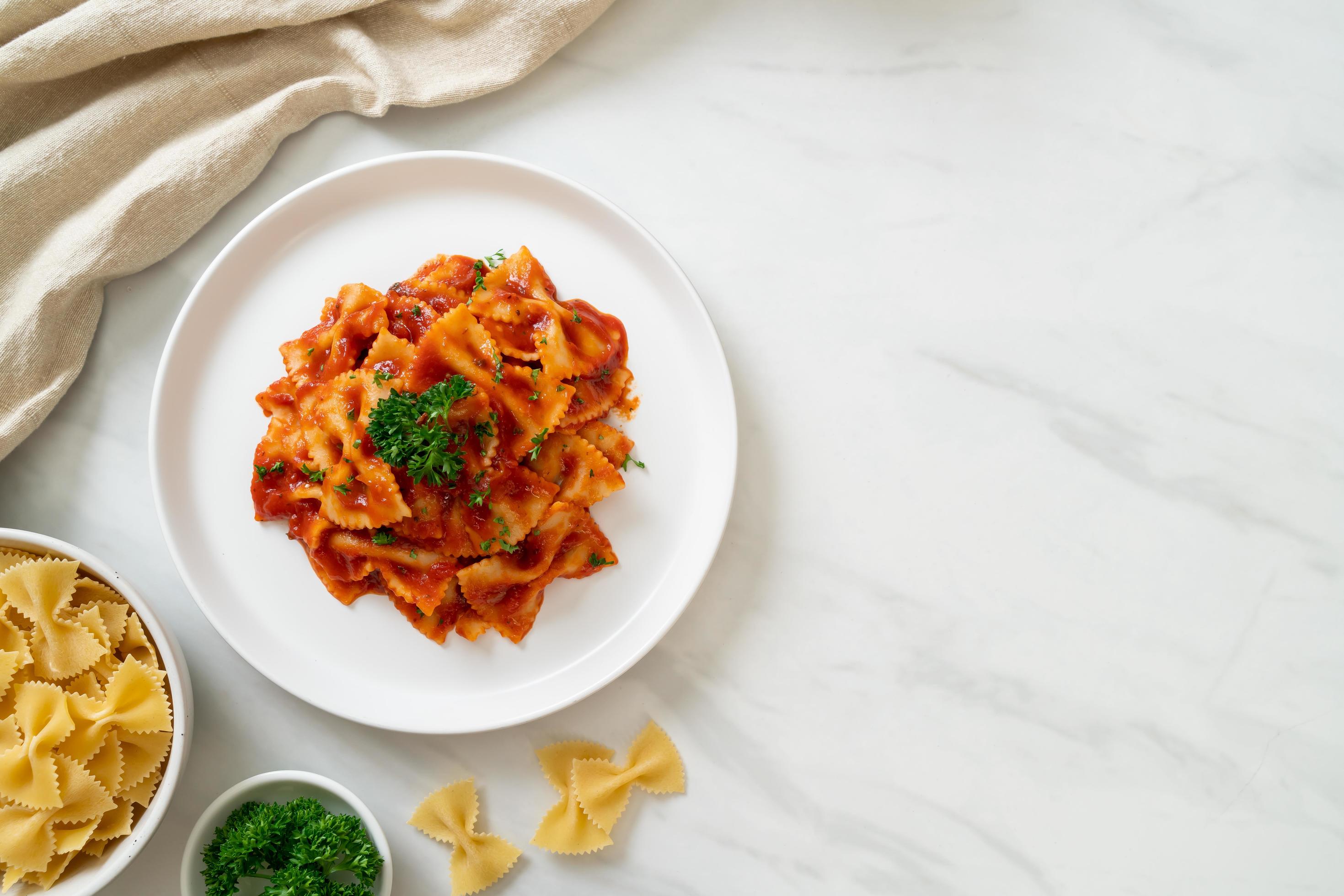 Farfalle pasta in tomato sauce with parsley – Italian food style Stock Free