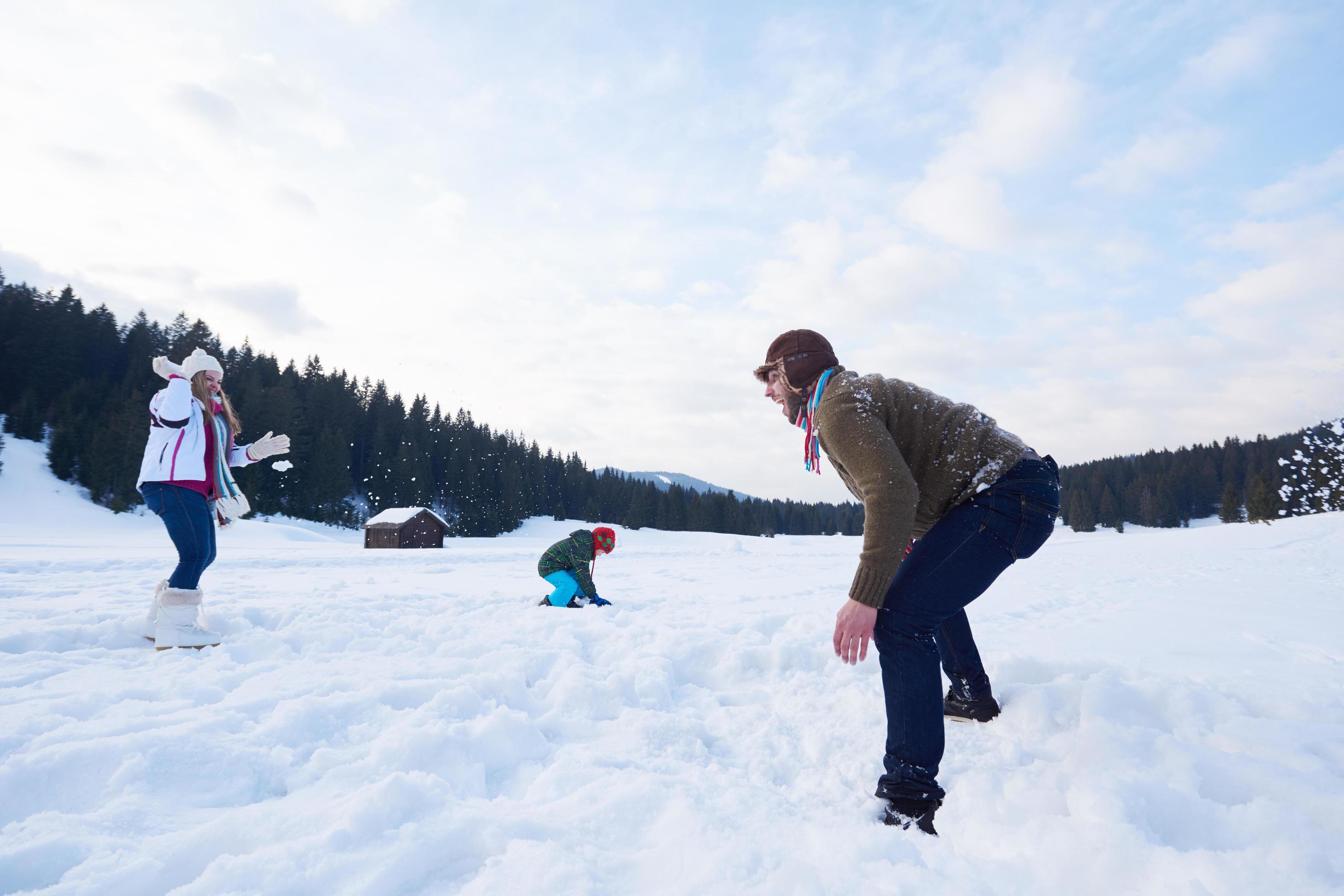 happy family playing together in snow at winter Stock Free