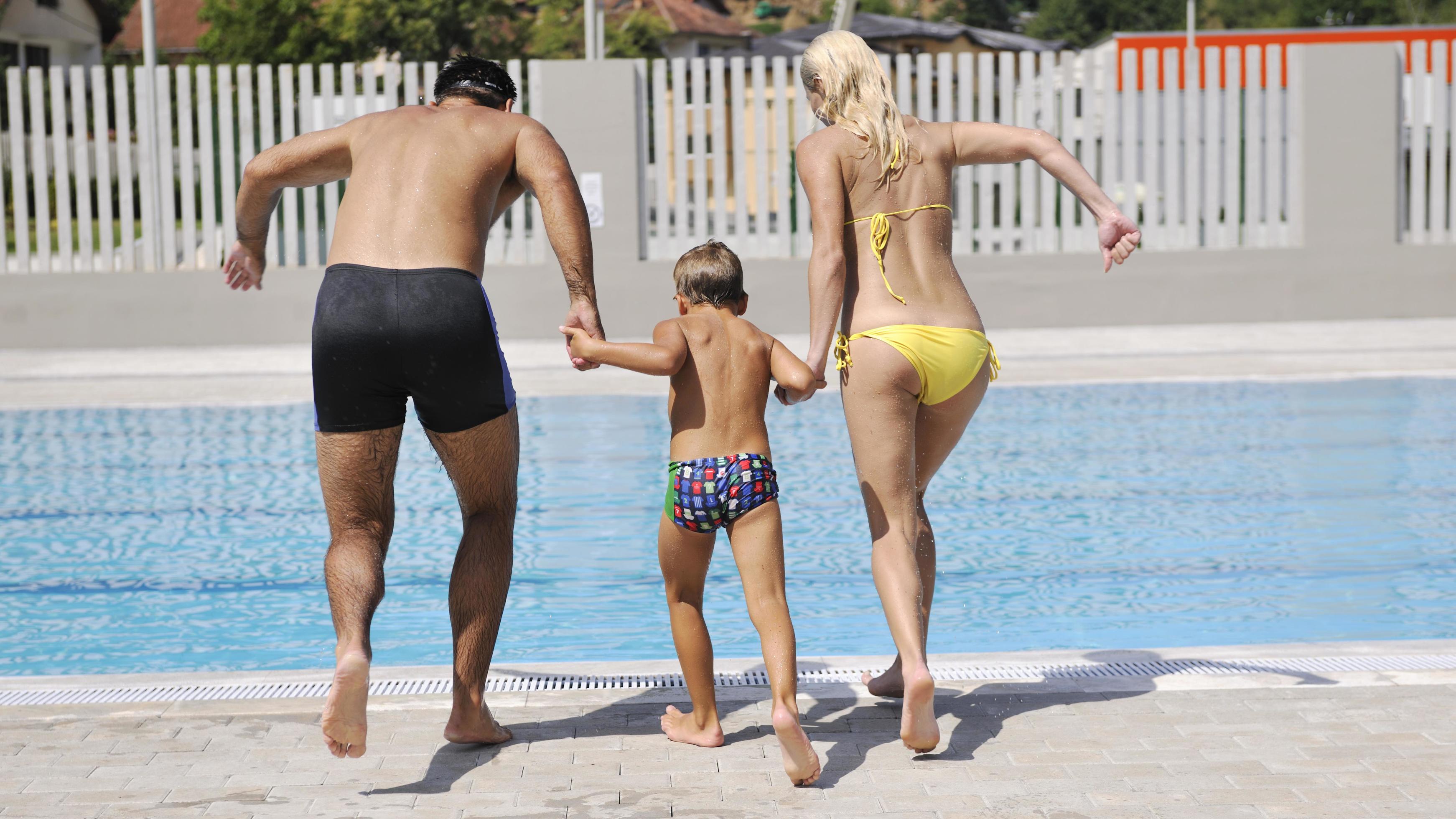 happy young family have fun on swimming pool Stock Free