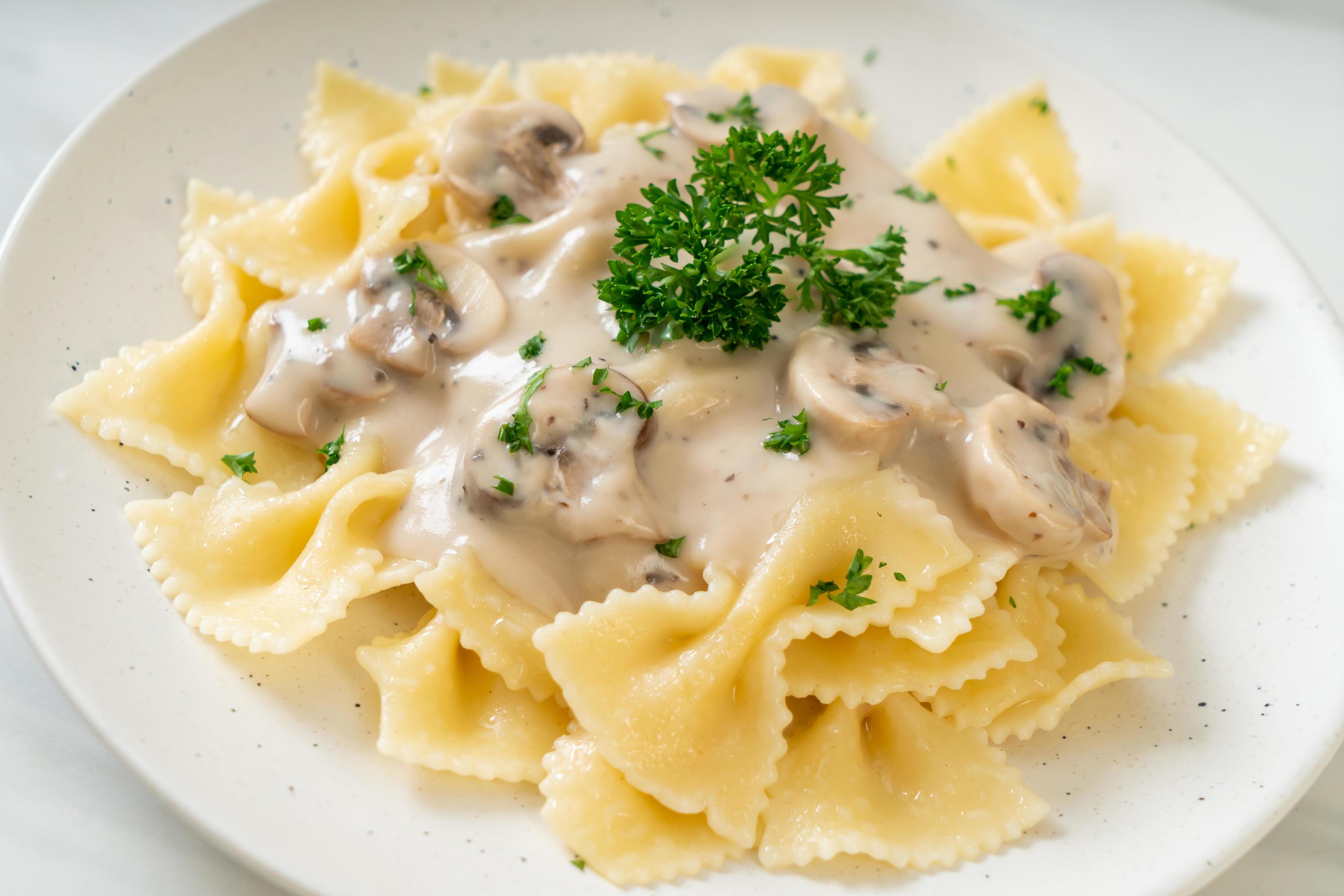 Farfalle pasta with mushroom white cream sauce – Italian food style Stock Free