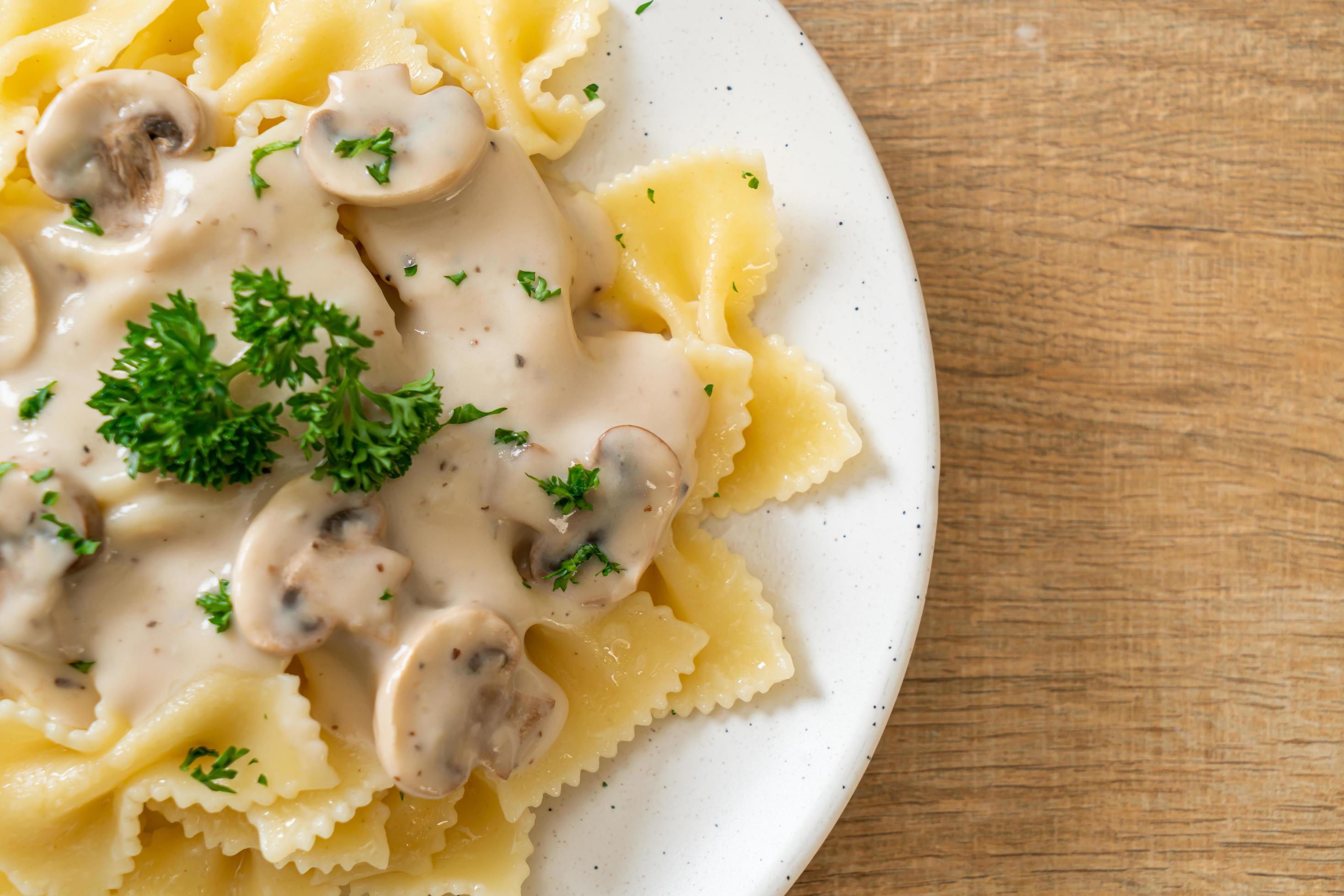 Farfalle pasta with mushroom white cream sauce – Italian food style Stock Free