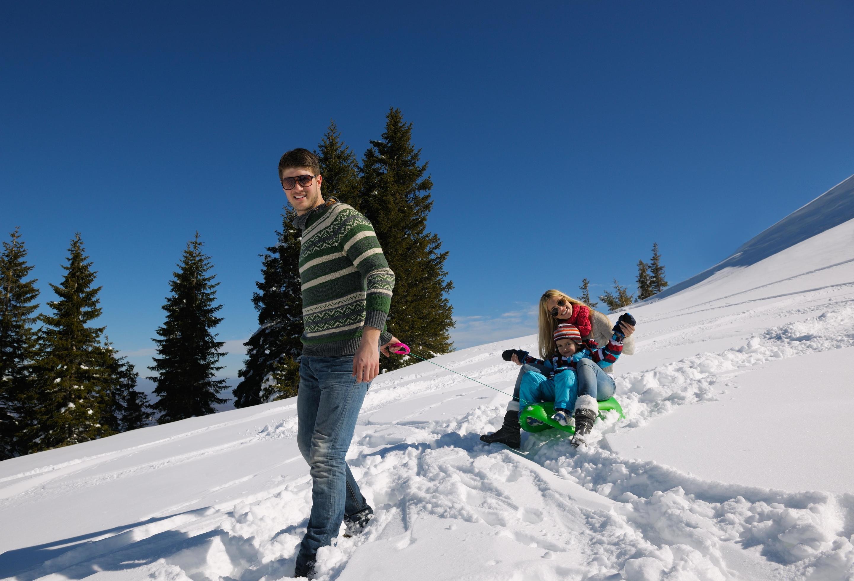 family having fun on fresh snow at winter vacation Stock Free