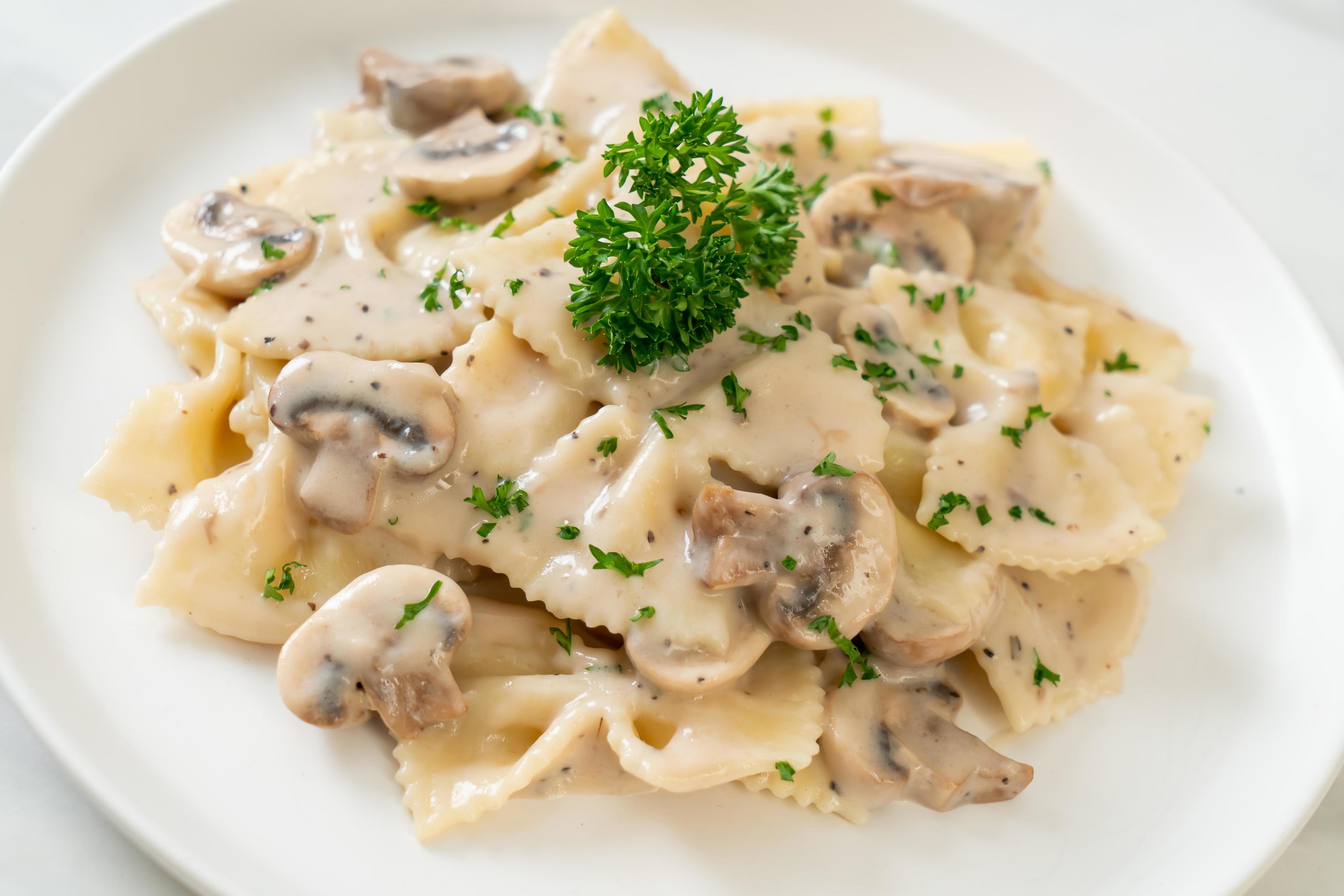 Farfalle pasta with mushroom white cream sauce – Italian food style Stock Free