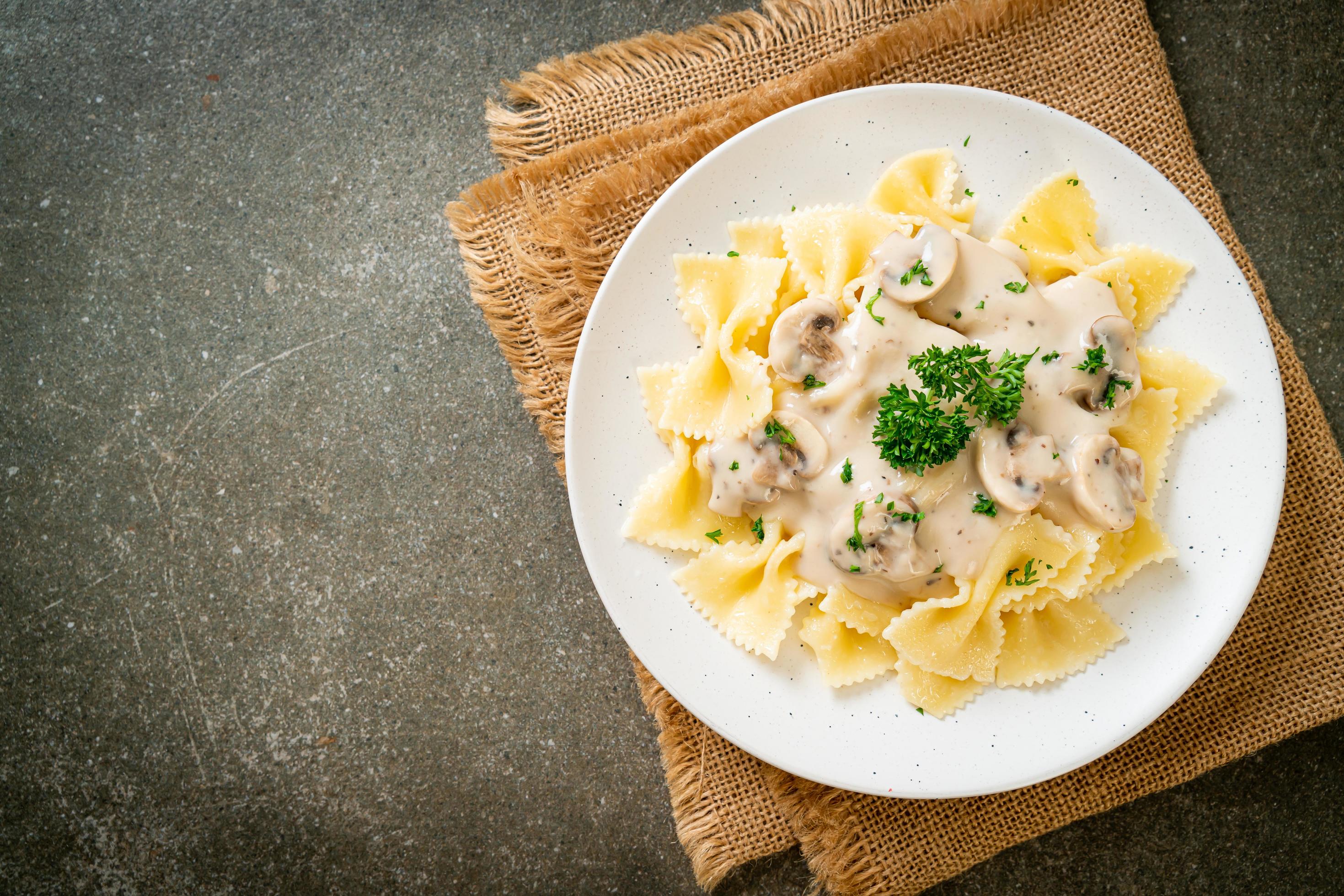 Farfalle pasta with mushroom white cream sauce – Italian food style Stock Free