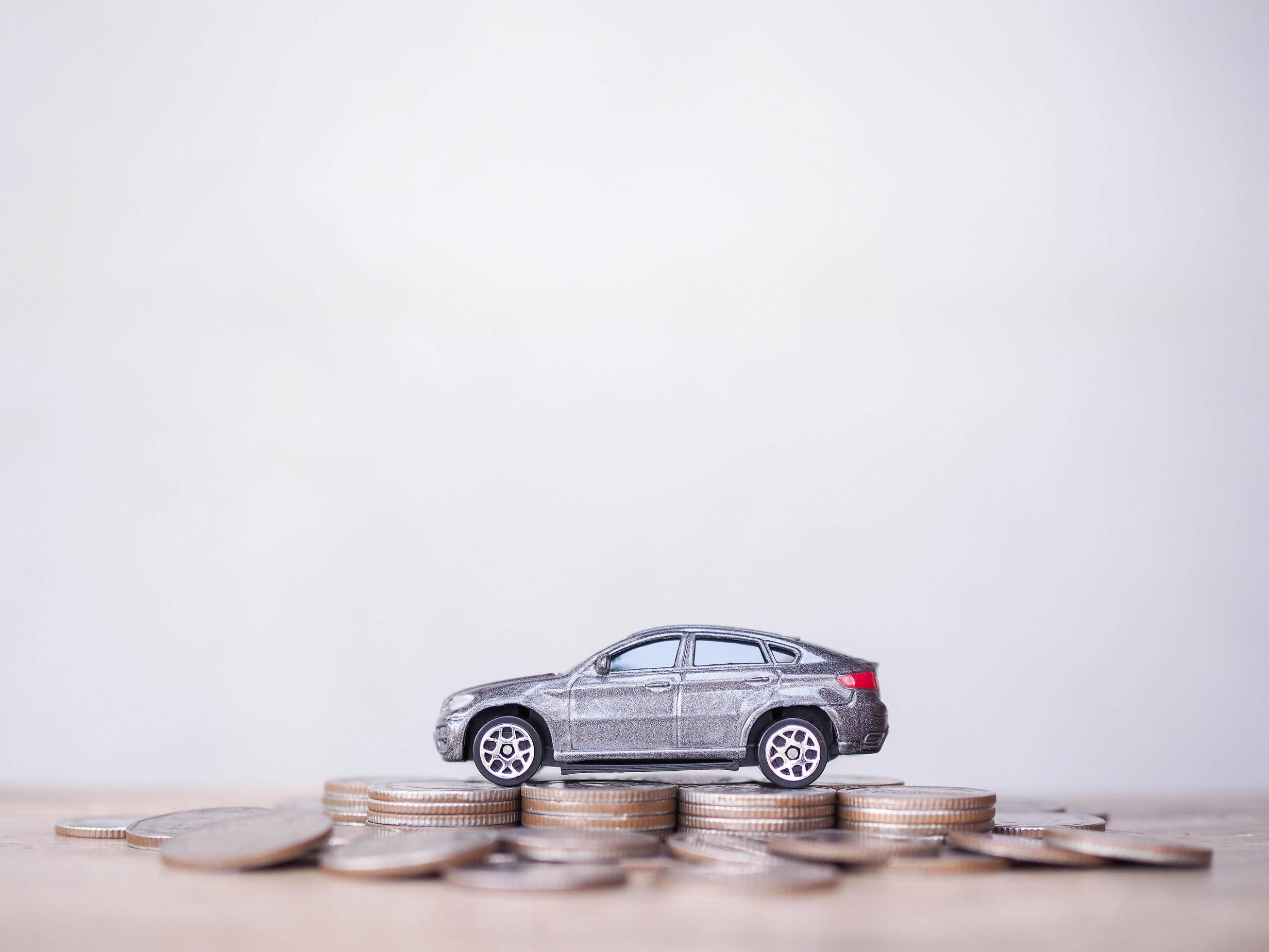 Toy cars on stack of coins. The concept of saving money and manage to success transport business Stock Free