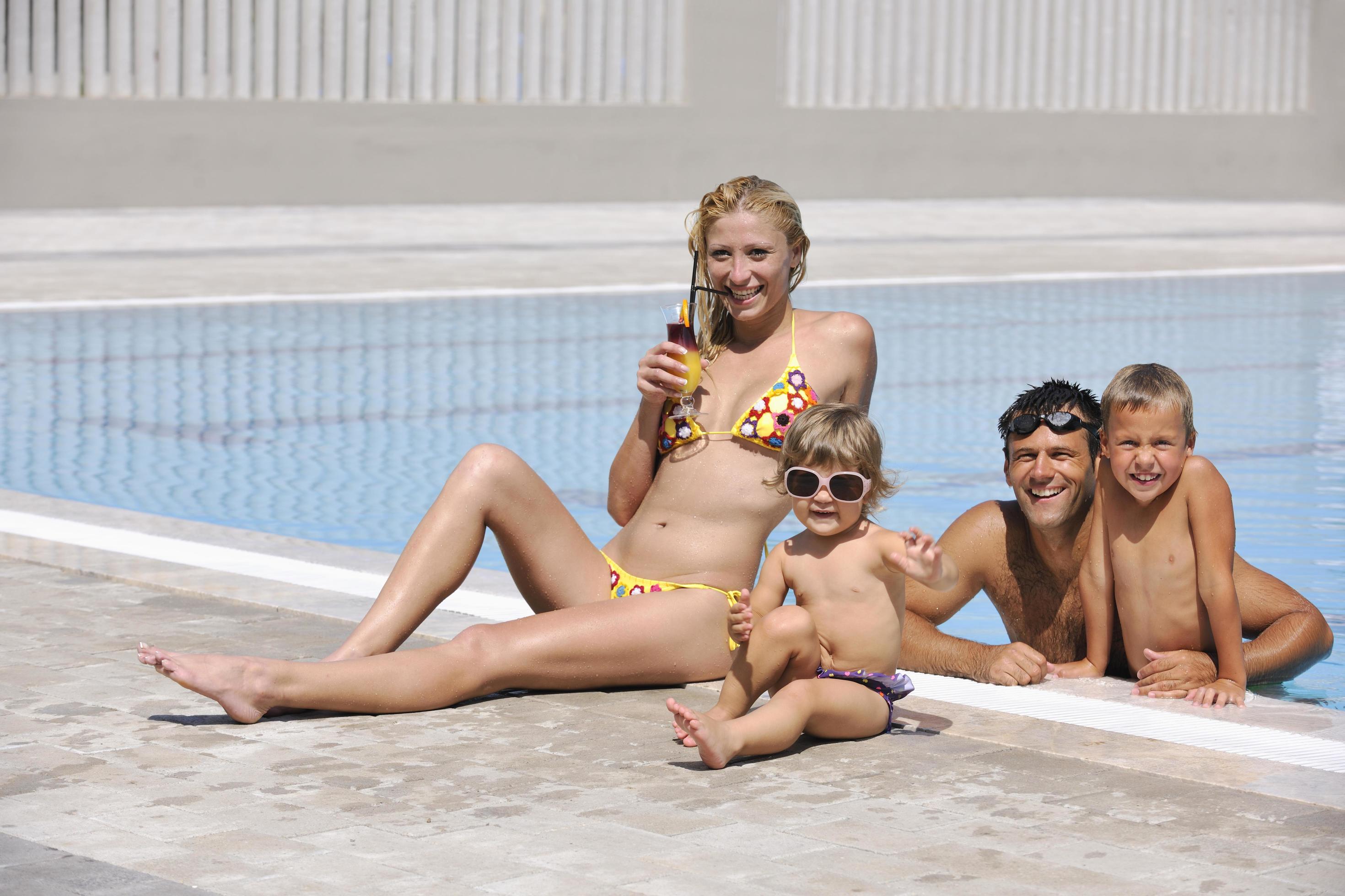 happy young family have fun on swimming pool Stock Free