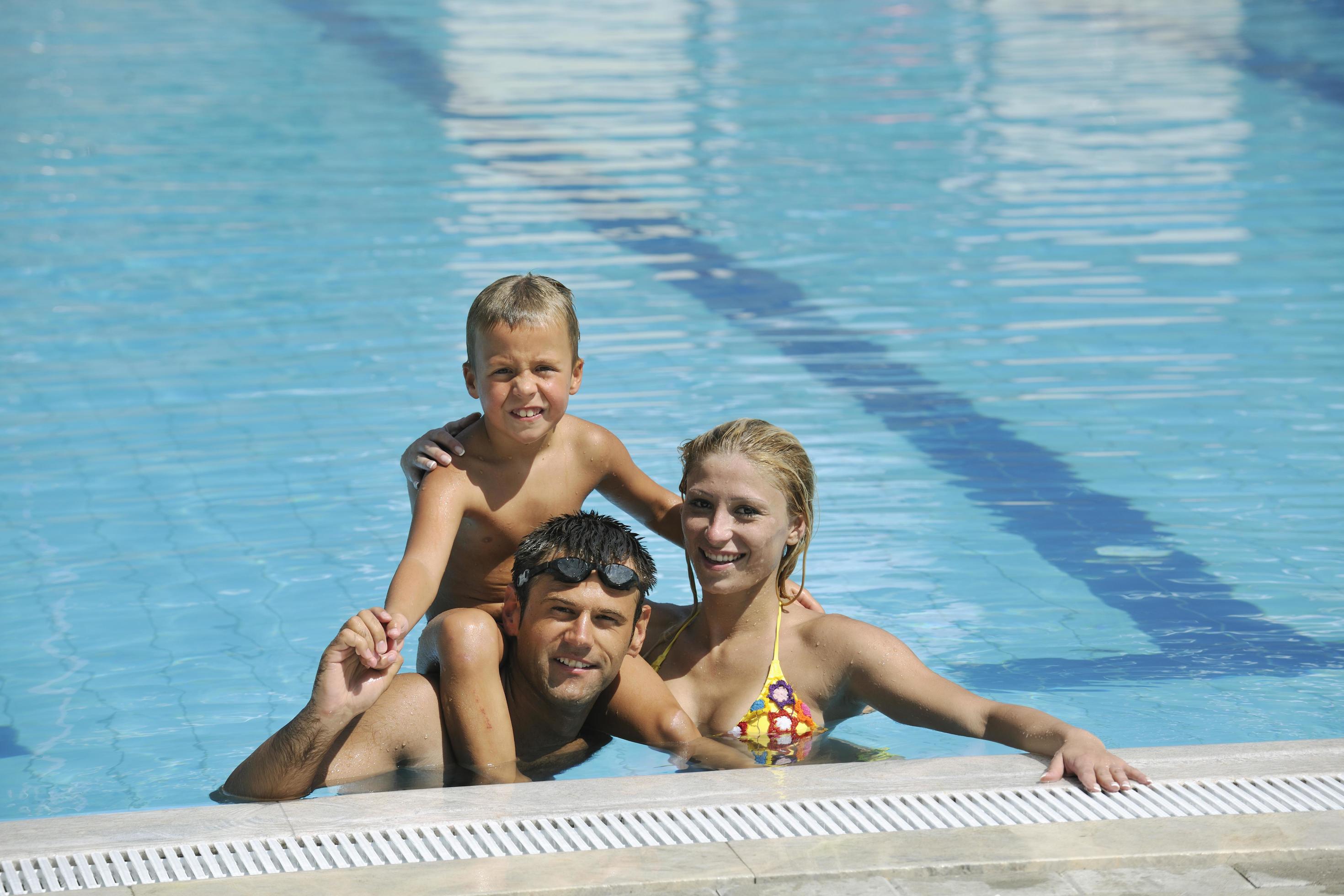 happy young family have fun on swimming pool Stock Free