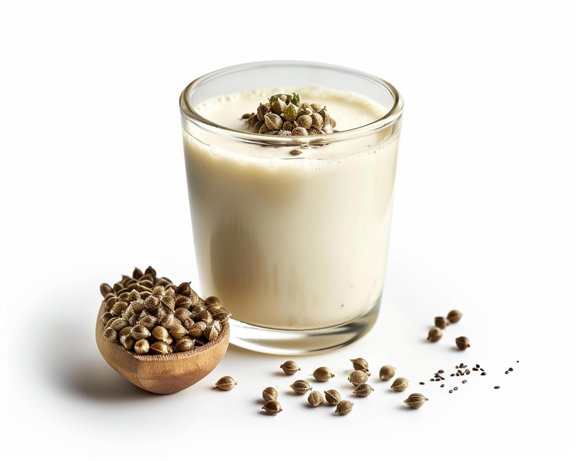 a glass of milk with hemp seeds on a wooden spoon Stock Free