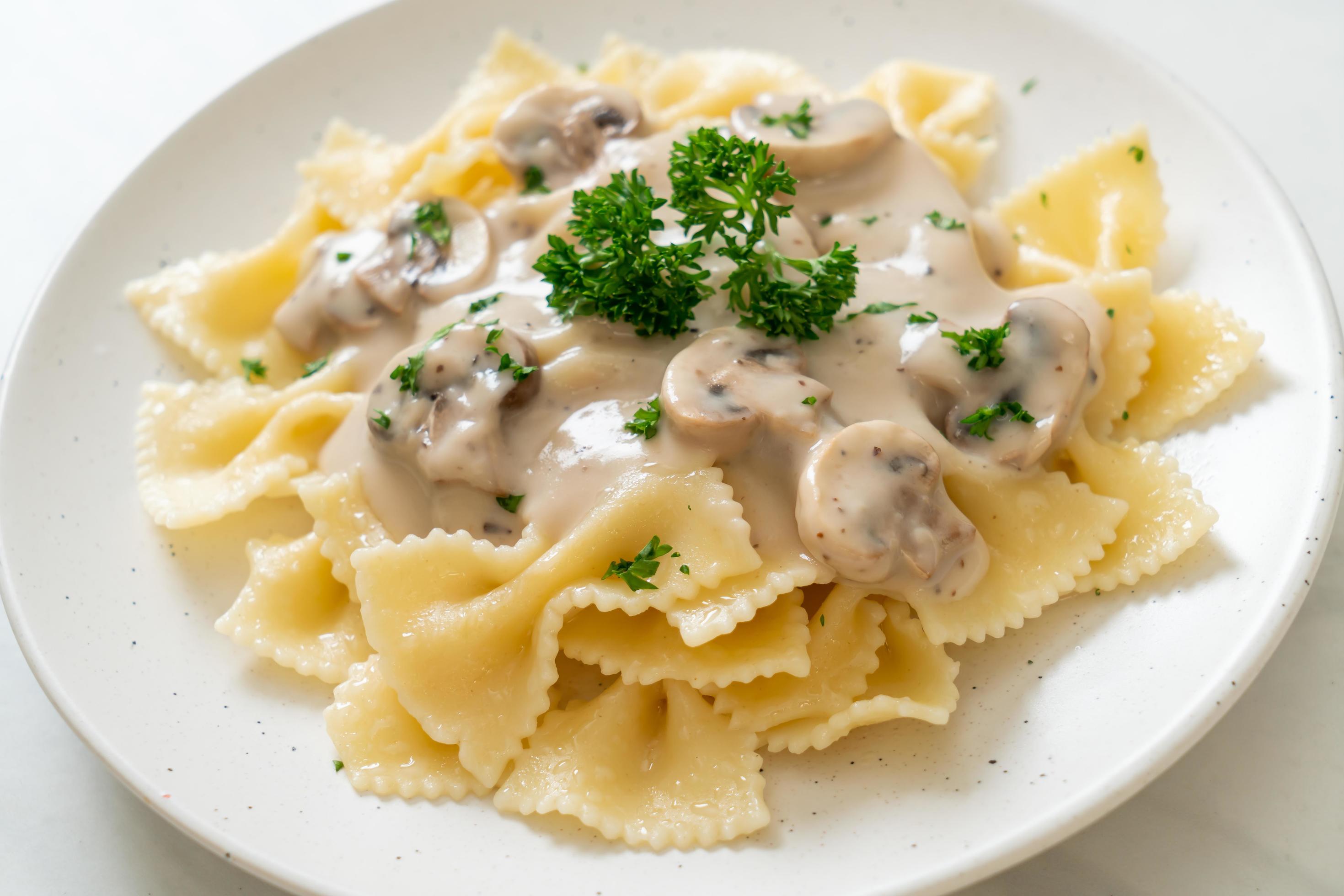 Farfalle pasta with mushroom white cream sauce – Italian food style Stock Free