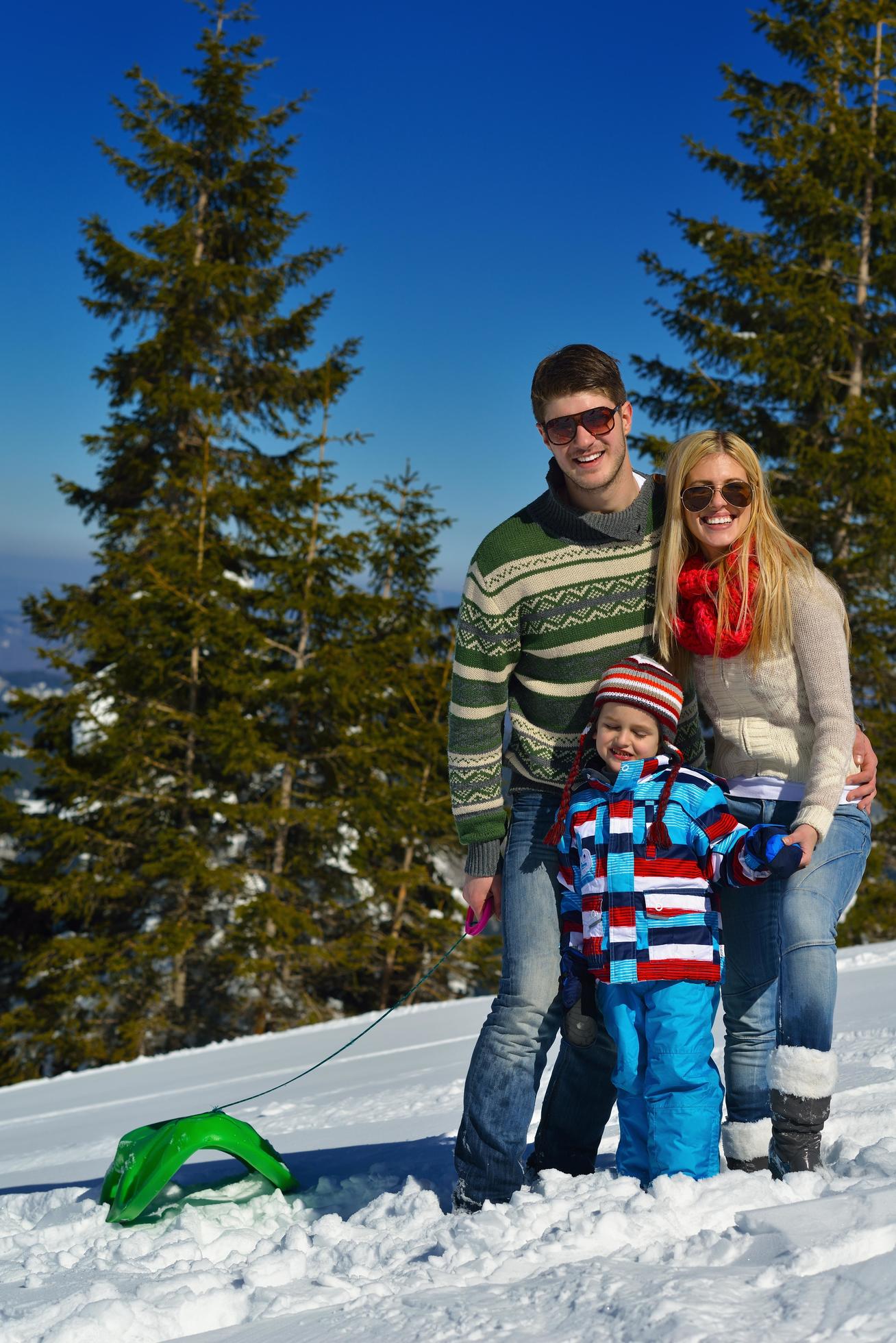 family having fun on fresh snow at winter vacation Stock Free